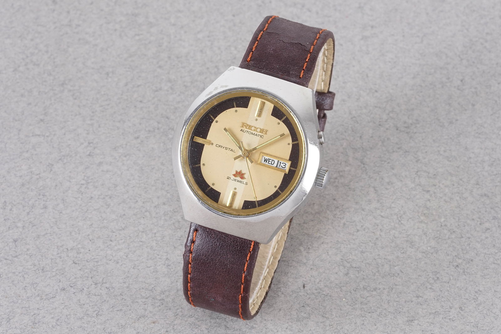 RICOH CRYSTAL AUTOMATIC DAY DATE WRISTWATCH: RICOH CRYSTAL AUTOMATIC DAY DATE WRISTWATCH, this watch is fitted with a circular two tone dial with a day date window, hour markers and hands. The 37mm case is fitted with a crown and a screw down ca