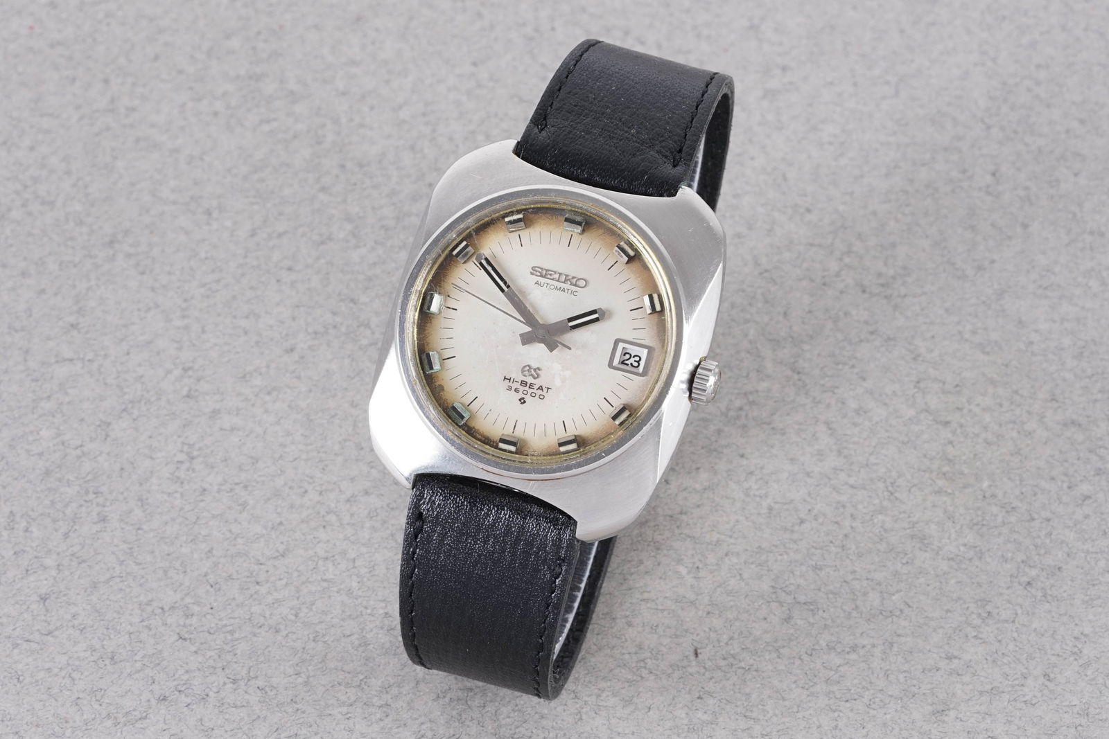 GRAND SEIKO HI-BEAT 3600 AUTOMATIC DATE REF. 6145-8020: GRAND SEIKO HI-BEAT 3600 AUTOMATIC DATE REF. 6145-8020, this watch is a ref. 6145-8020 and is fitted with a circular patina dial with a date window, applied block hour markers and hands. The 36mm stai