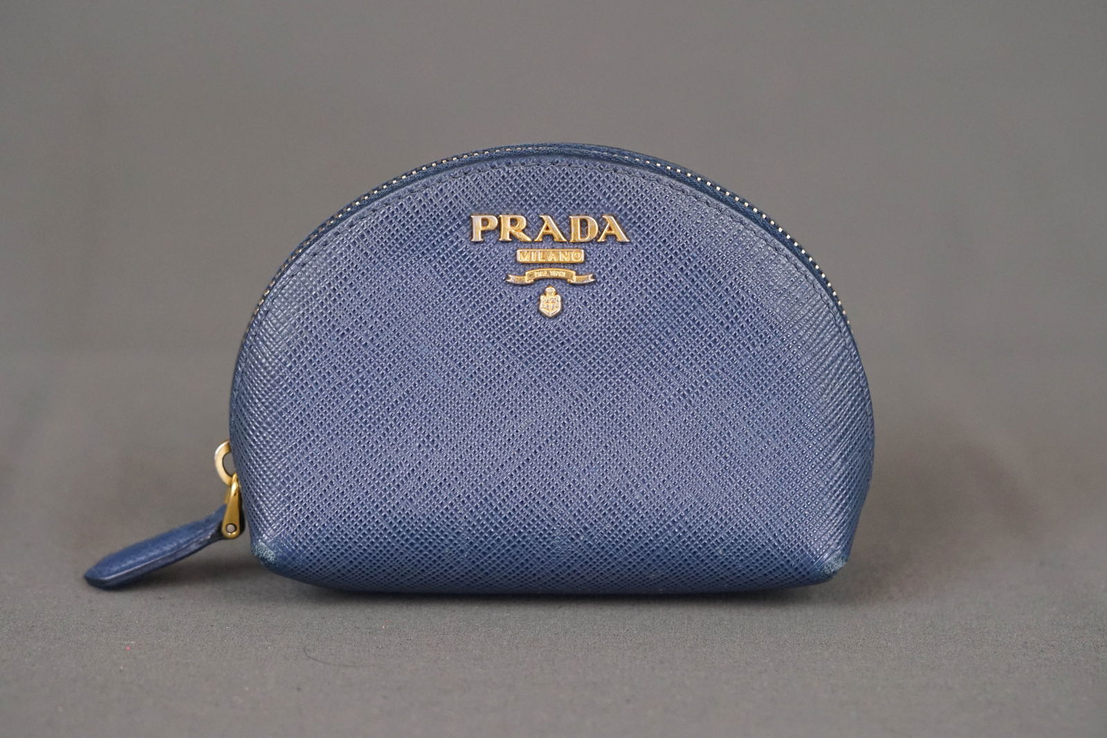 PRADA BLUE LEATHER WALLET COIN PURSE 1MM1404: PRADA BLUE LEATHER WALLET COIN PURSE 1MM1404, width 15cm, height 10cm, depth 3cm. PLEASE NOTE: *This lot is elected for VAT (20%) on the hammer which will not apply for successful bidders outside of