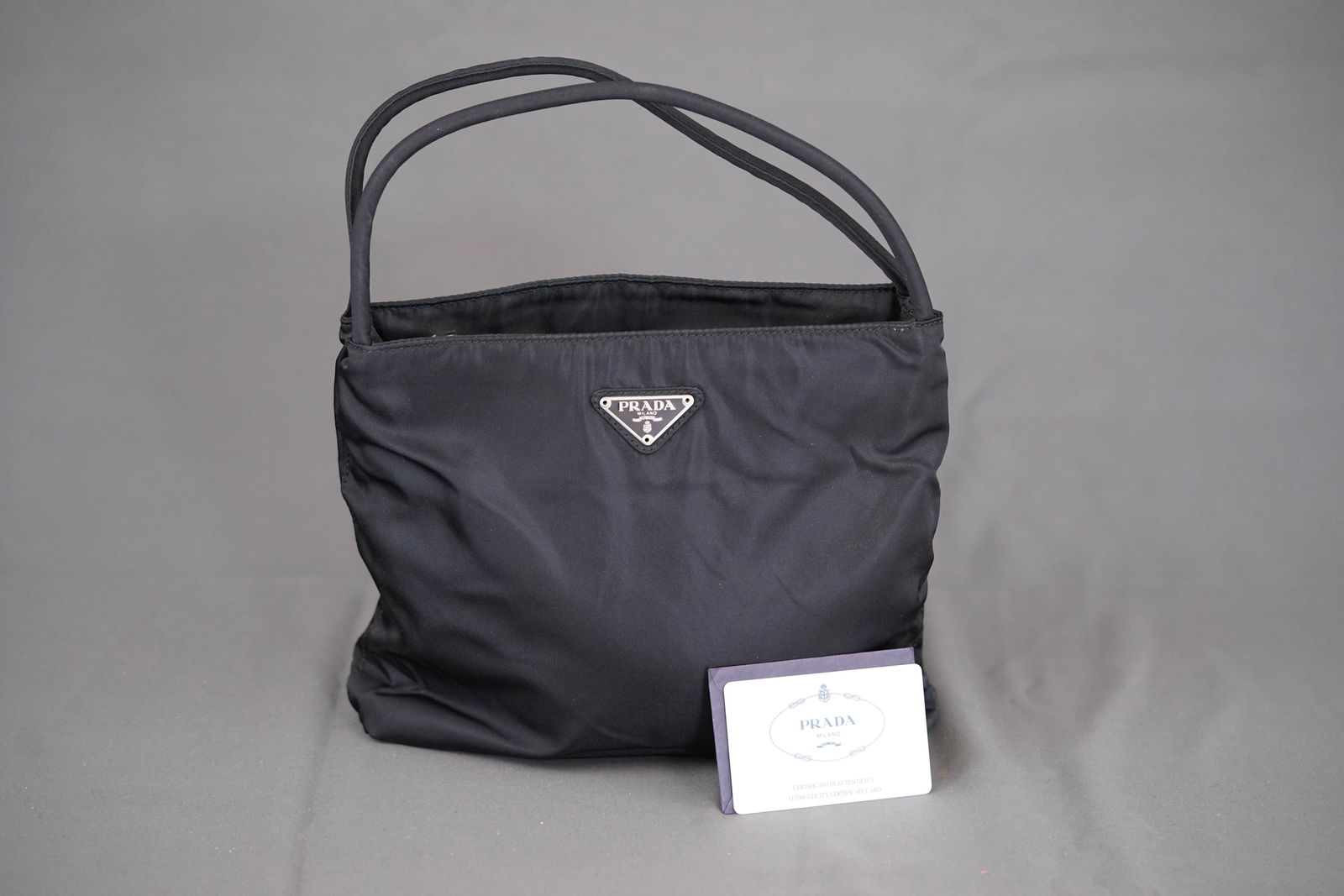 PRADA POCONO HANDBAG NYLON BLACK: PRADA POCONO HANDBAG NYLON BLACK, width 23cm, height 21cm, depth 5cm, condition rank B. PLEASE NOTE: *This lot is elected for VAT (20%) on the hammer which will not apply for successful bidders