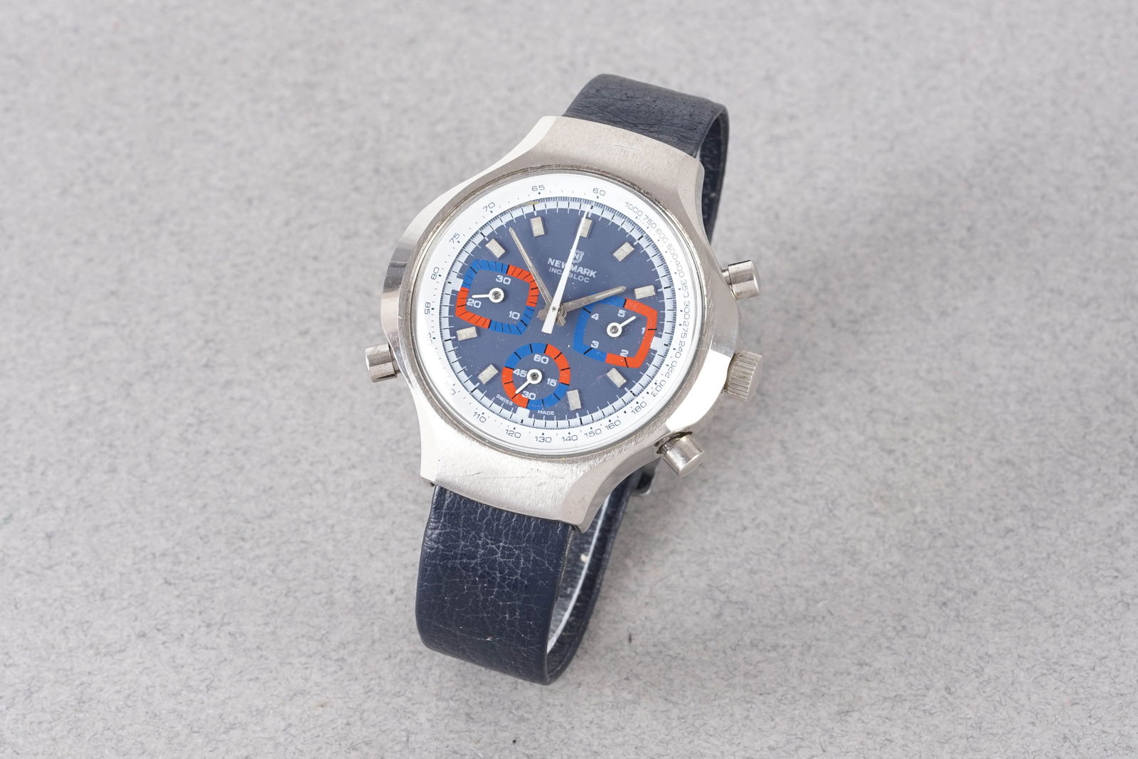 NEWMARK CHRONOGRAPH WRISTWATCH: NEWMARK CHRONOGRAPH WRISTWATCH, this watch is fitted with a circular blue triple register dial with applied hour markers and hands. The 44mm case is fitted with a crown, pushers and a case back.