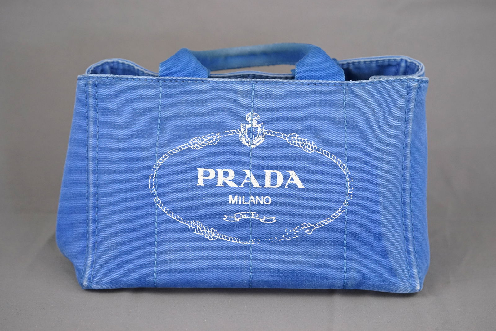 PRADA CANAPA M TOTE BAG CANVAS BLUE: PRADA CANAPA M TOTE BAG CANVAS BLUE, width 34cm, height 22cm, depth 22cm, condition rank BC. PLEASE NOTE: *This lot is elected for VAT (20%) on the hammer which will not apply for successful bidders