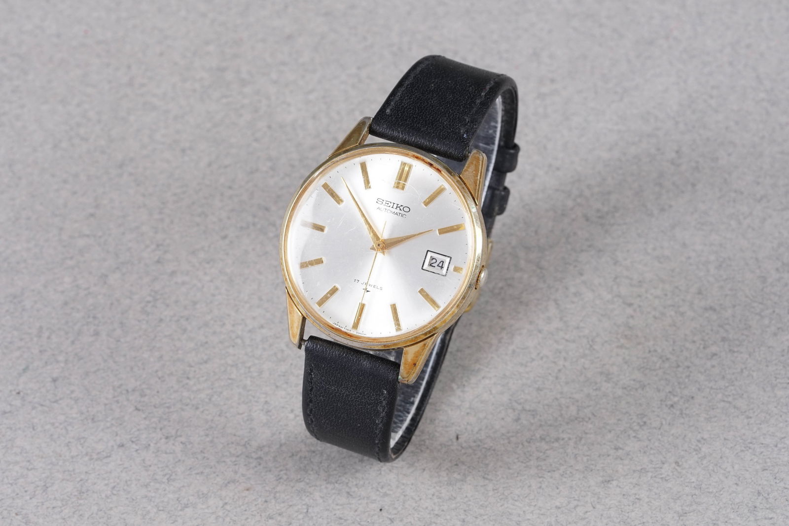 SEIKO AUTOMATIC DATE GOLD PLATED WRISTWATCH: SEIKO AUTOMATIC DATE GOLD PLATED WRISTWATCH, this watch is fitted with a circular silver dial with a date window, gold tone hour markers and hands. The 37mm gold plated case is fitted with a crown