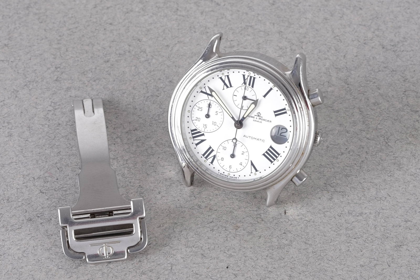 BAUME & MERCIER BAUMATIC DATE CHRONOGRAPH REF. 6103: BAUME & MERCIER BAUMATIC DATE CHRONOGRAPH REF. 6103, this watch is a ref. 6103 and is fitted with a circular white triple register dial with a date window, hour markers and hands. The 37mm