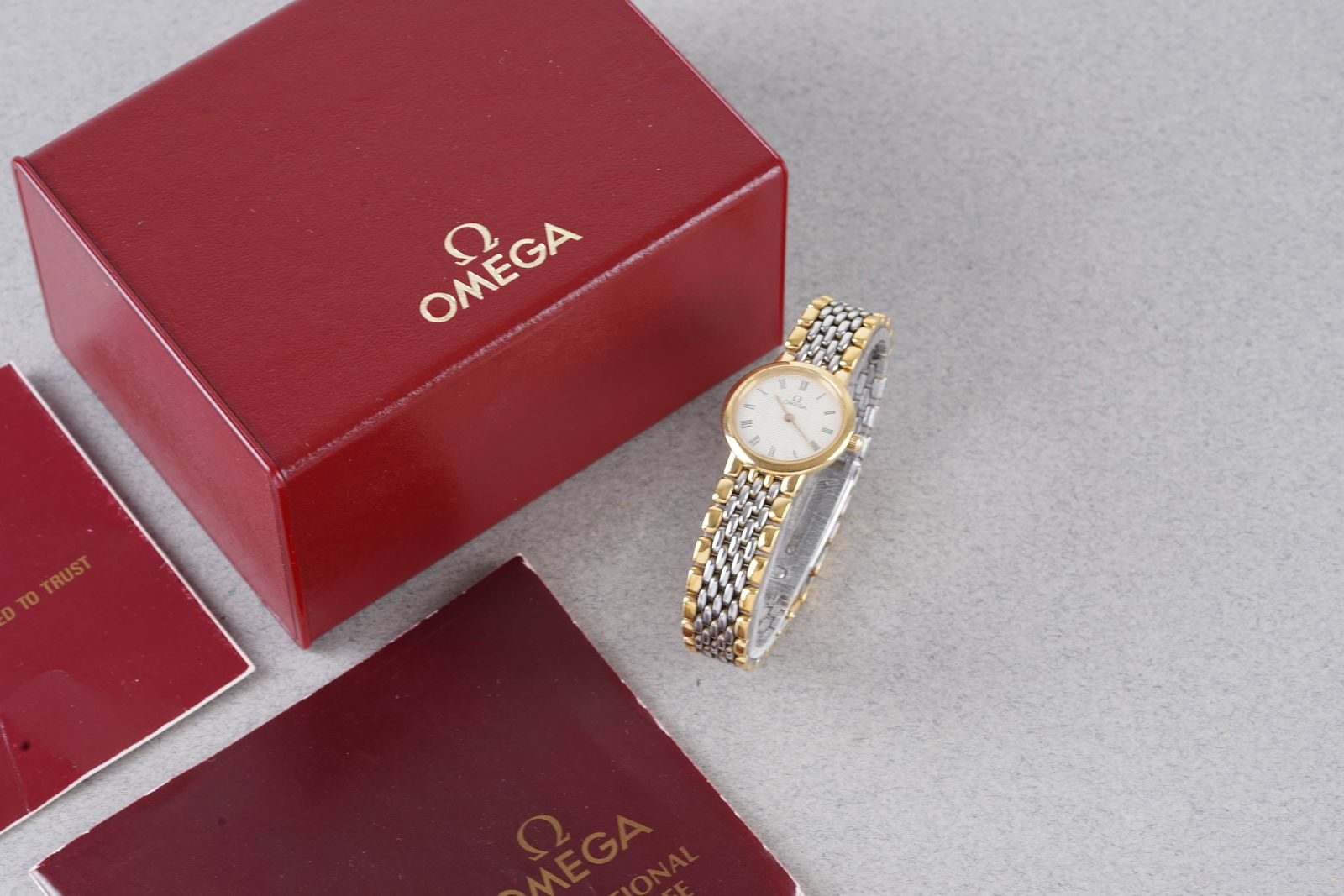 *TO BE SOLD WITHOUT RESERVE* OMEGA TWO TONE DRESS WATCH W/ BOX & GUARANTEE PAPERS CIRCA 1987: *TO BE SOLD WITHOUT RESERVE* OMEGA TWO TONE DRESS WATCH W/ BOX & GUARANTEE PAPERS CIRCA 1987, this watch is fitted with a circular dial with hour markers and hands. The 22mm case is fitted with a