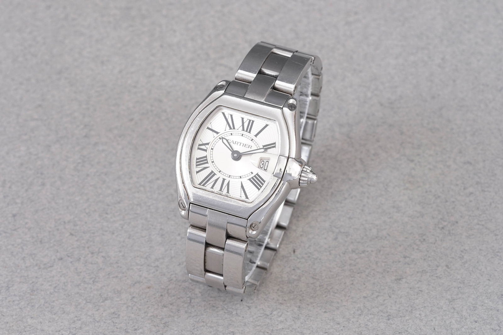 CARTIER ROADSTER DATE REF. 2675: CARTIER ROADSTER DATE REF. 2675, this watch is a ref. 2675 and is fitted with a barrell shaped silver dial with roman numeral hour markers and hands. The 31mm stainless steel case is fitted with