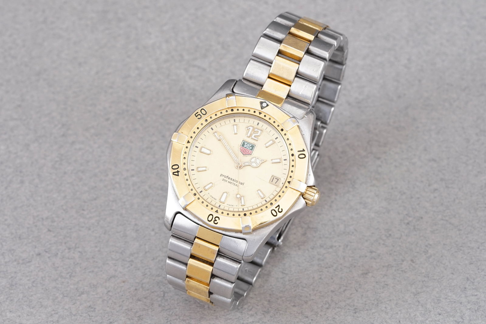 TAG HEUER PROFESSIONAL DATE TWO TONE W/ BOX REF. WK1121: TAG HEUER PROFESSIONAL DATE TWO TONE W/ BOX REF. WK1121, this watch is a ref. WK1121 and is fitted with a circular champagne dial with hour markers and hands. The 37mm stainless steel case is