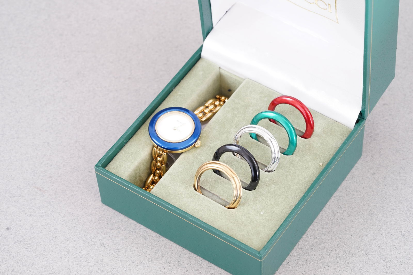 GUCCI MULTI BEZEL WRISTWATCH W/ BOX: GUCCI MULTI BEZEL WRISTWATCH W/ BOX, this watch is a fitted with a circular white dial with gold tone hands. The 26mm case is fitted with a crown and a case back. Inside is a quartz movement