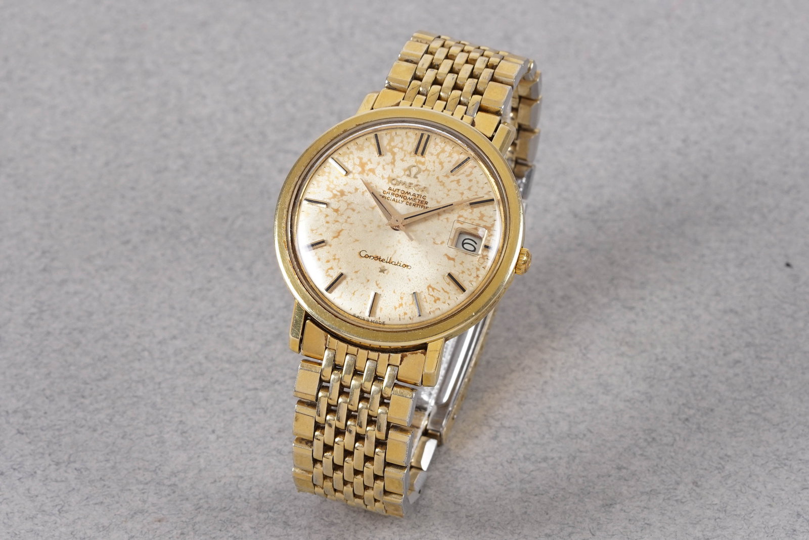 OMEGA CONSTELLATION GOLD PLATED AUTOMATIC CHRONOMETER DATE WRISTWATCH: OMEGA CONSTELLATION GOLD PLATED AUTOMATIC CHRONOMETER DATE WRISTWATCH, this watch is fitted with a circular patina dial with a date window, gold applied baton hour markers and dauphine hands. The