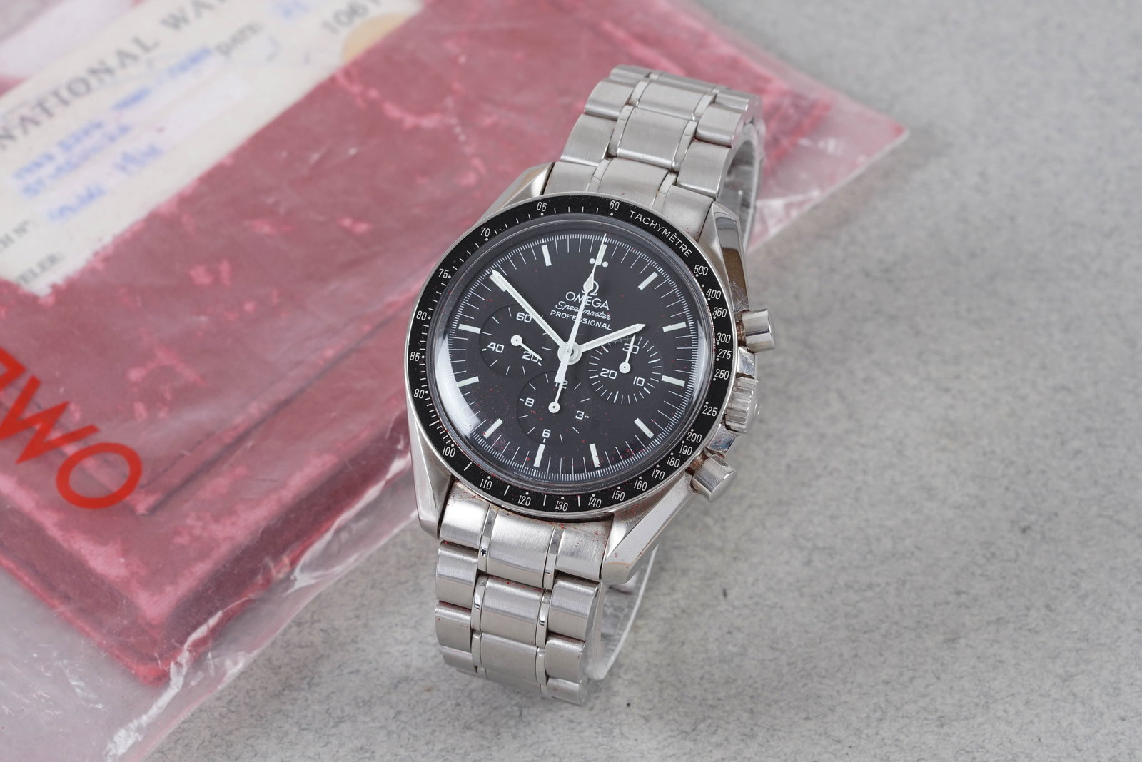 OMEGA SPEEDMASTER MOONWATCH W/ GUARANTEE CARD REF. 1450022 CIRCA 2001: this watch is a ref. 1450022 and is fitted with a round black dial and 3 sub dials baton hour markers and hands hands. The 42 mm steel case is fitted with an omega crown start,stop reset pushers and a