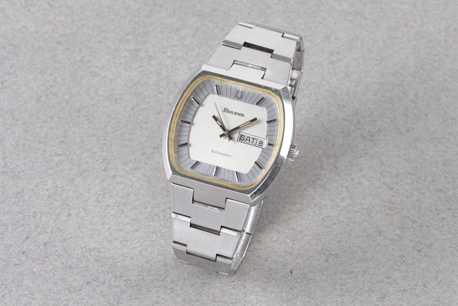 BULOVA AUTOMATIC DAY DATE REF. 11AOACB CIRCA 1977: BULOVA AUTOMATIC DAY DATE REF. 11AOACB CIRCA 1977, this watch is a ref. 11AOACB and is fitted with a silver dial with a day date window, hour markers and hands. The 43mm stainless steel case is