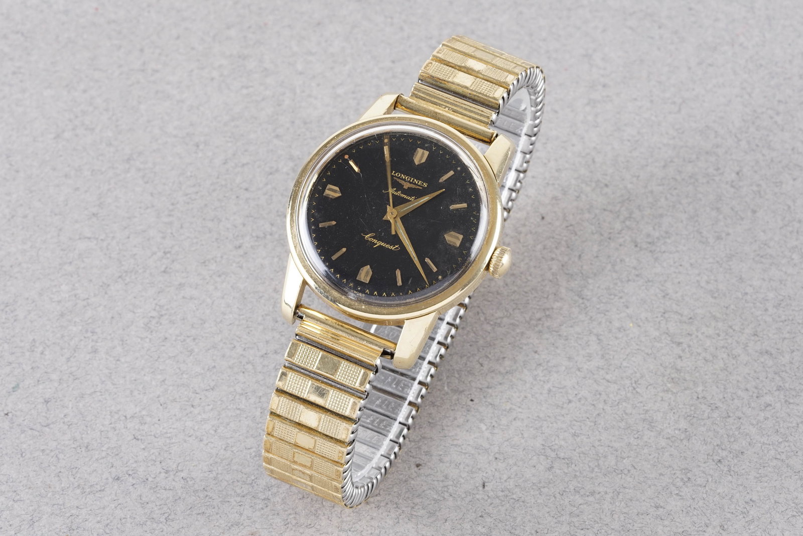 LONGINES CONQUEST AUTOMATIC GOLD PLATED WRISTWATCH: LONGINES CONQUEST AUTOMATIC GOLD PLATED WRISTWATCH, this watch is fitted with a circular black gloss dial with gold hour markers and hands. The 34mm gold plated case is fitted with a crown and a case
