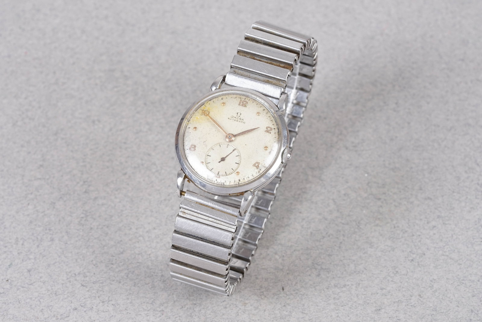 OMEGA AUTOMATIC 'BUMPER' REF. 2402-1 CIRCA 1947: OMEGA AUTOMATIC 'BUMPER' REF. 2402-1 CIRCA 1947, this watch is a ref. 2402-1 and is fitted with a round patina dial with sub seconds, number and dot hour markers and sword hands. The 33mm steel case