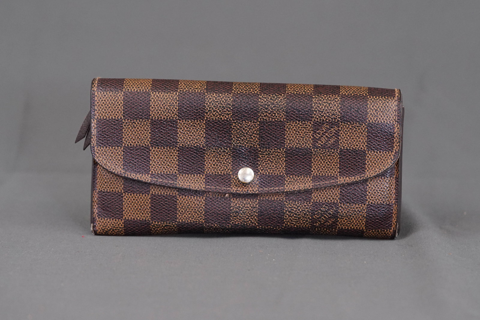 LOUIS VUITTON DAMIER PORTEFEUILLE EMILIE: LOUIS VUITTON DAMIER PORTEFEUILLE EMILIE, model number: N63019, width 19cm, height 9.5cm, depth 2.3cm. If you have any questions regarding this lot please contact us. For further information on our