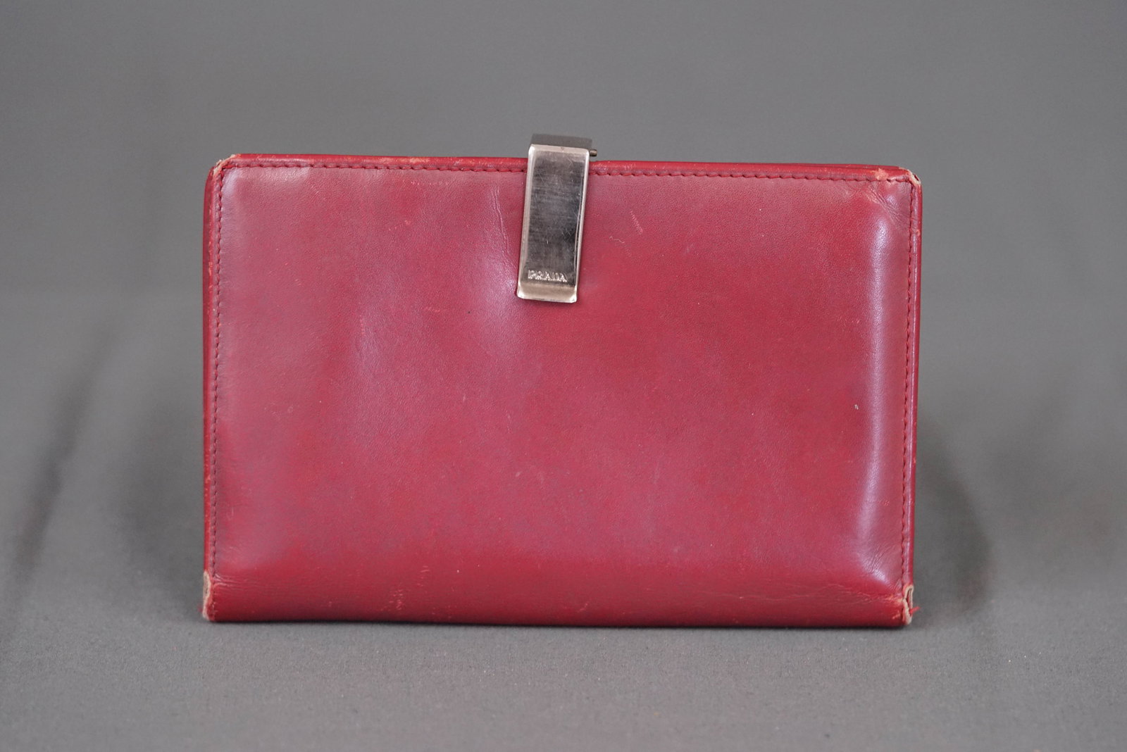 PRADA BORDEAUX LEATHER WALLET: PRADA BORDEAUX LEATHER WALLET, width 15cm, height 10cm, depth 2cm. If you have any questions regarding this lot please contact us. For further information on our auction, please refer to our T &