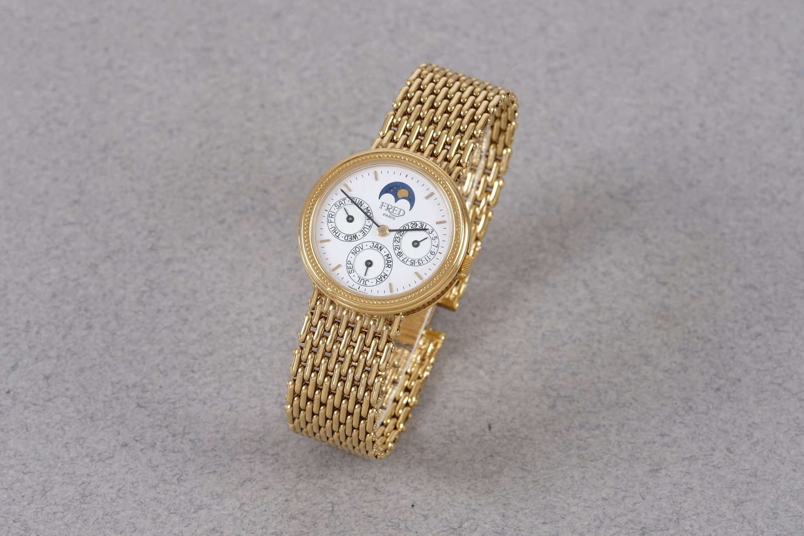 FRED TRIPLE CALENDAR GOLD PLATED WRISTWATCH W/ BOX: This watch is fitted with a round white dial with day,date, month,moonphase sub dials, baton hour markers and hands. The 28 mm gold plated case is fitted with a crown and a snap case back. Inside is