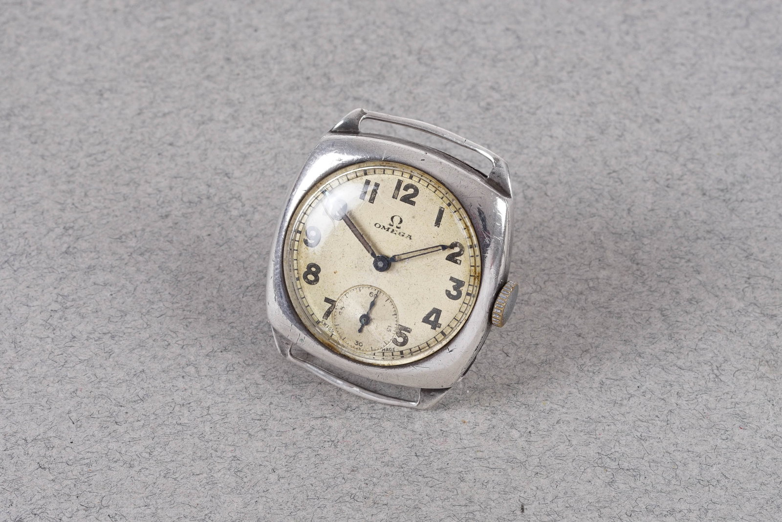 OMEGA 925 STERLING SILVER TRENCH STYLE WRISTWATCH: This watch is fitted with a circular patina dial with subsidiary seconds numbered hour markers and pencil hands. The 30 mm square silver case is fitted with a crown and a snapcase back. Inside is a