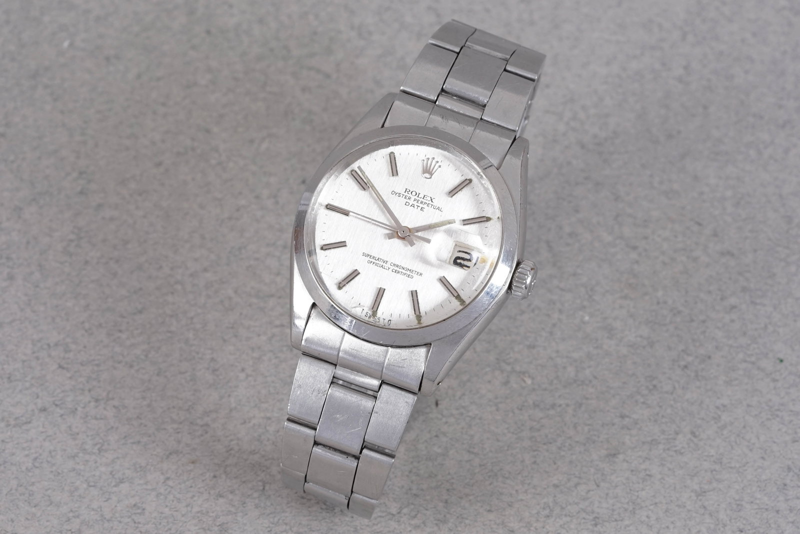 ROLEX OYSTER PERPETUAL DATE REF. 1500 CIRCA 1972: ROLEX OYSTER PERPETUAL DATE REF. 1500 CIRCA 1972, this watch is fitted with a circular white linen sigma dial with date window baton hour markers and hands. The 35mm steel case is fitted with a Rolex
