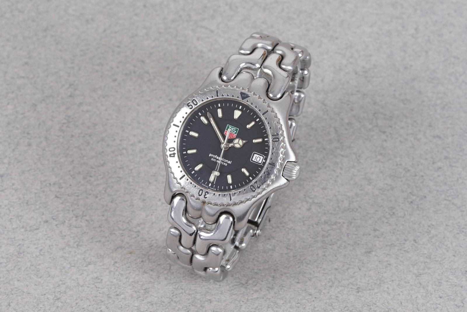 TAG HEUER PROFESSIONAL 200 DATE REF. WG1214-K0: TAG HEUER PROFESSIONAL 200 DATE REF. WG1214-K0, and is fitted with a circular black dial with a date window baton hour markers and Mercedes hands. The 34mm steel case is fitted with a screw down