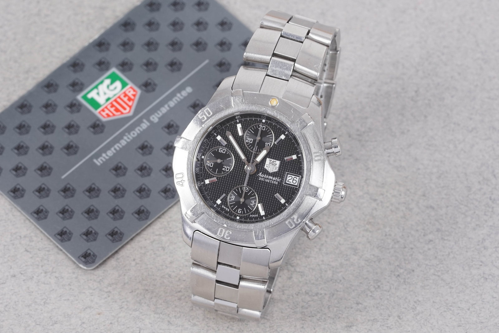 TAG HEUER EXCLUSIVE AUTOMATIC CHRONOGRAPH W/ GUARANTEE REF. CN2111: TAG HEUER EXCLUSIVE AUTOMATIC CHRONOGRAPH W/ GUARANTEE REF. CN2111, this watch is fitted with a circular black dial with date window and 3 sub dials, baton hour markers and hands. The 40mm steel case