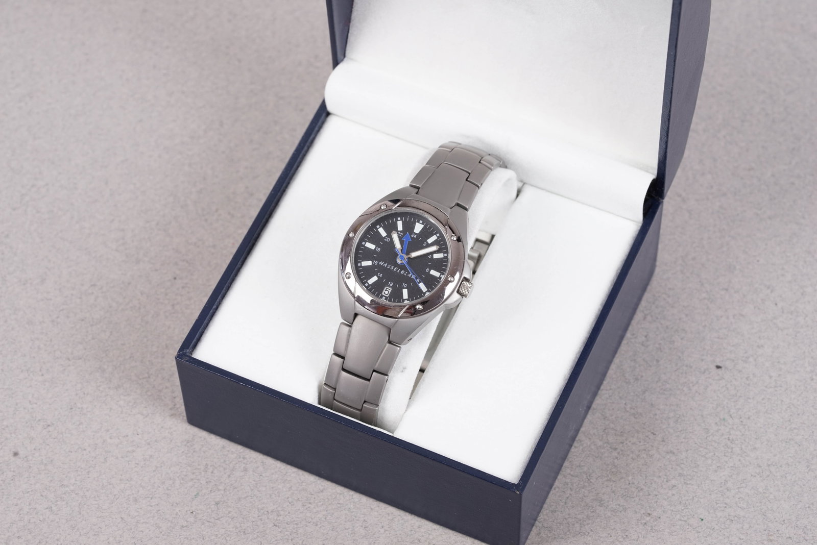 *TO BE SOLD WITHOUT RESERVE* HASSELBLAD WRISTWATCH W/ BOX: *TO BE SOLD WITHOUT RESERVE* HASSELBLAD WRISTWATCH W/ BOX, this watch is fitted with a circular blue dial with date window, baton hour markers and pencil hands. The 33mm steel case is fitted with a