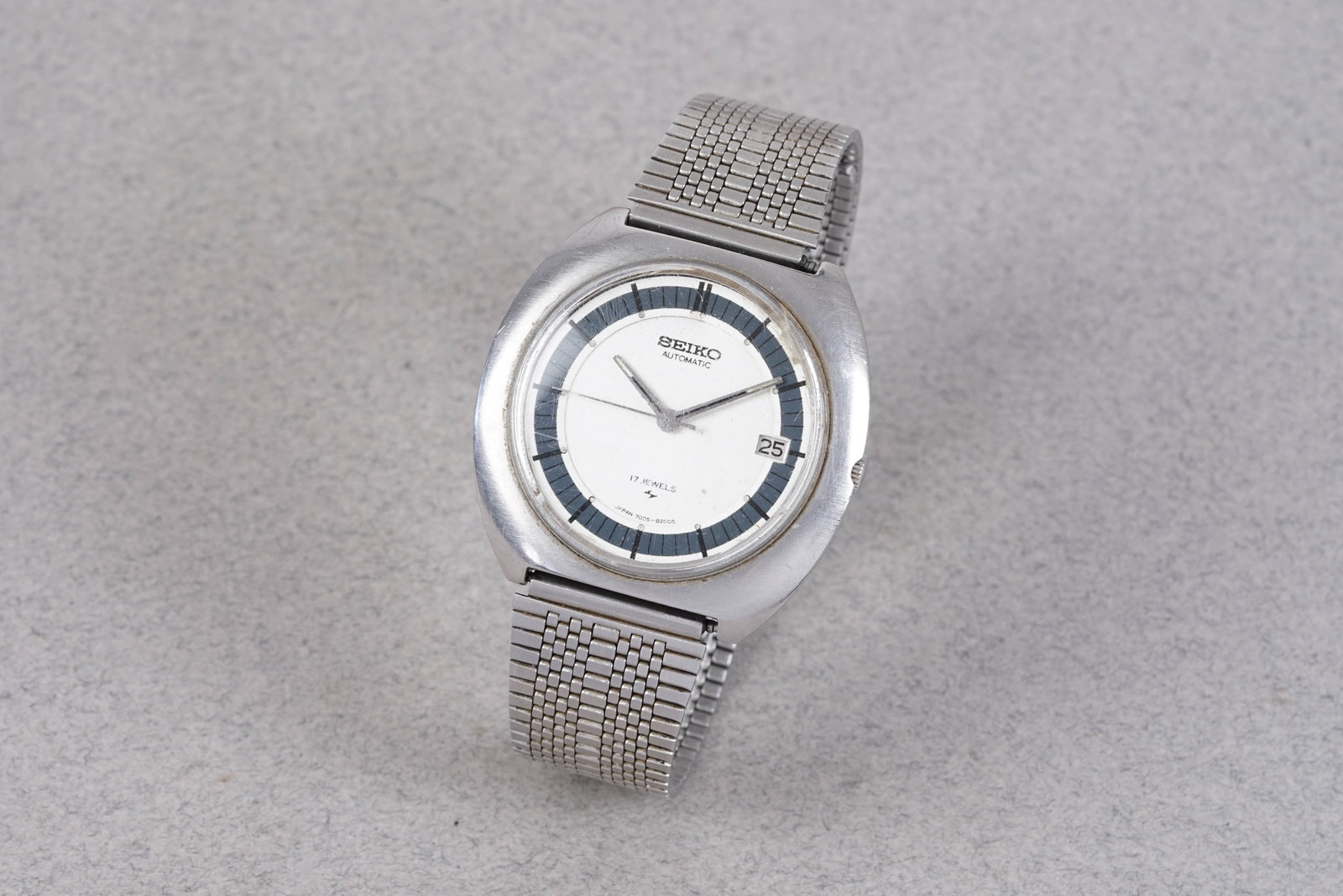 SEIKO AUTOMATIC DATE REF. 7005-8150: SEIKO AUTOMATIC DATE REF. 7005-8150, and is fitted with a circular white and blue dial with a date window, baton hour markers and hands. The 40mm steel case is fitted with a crown and screw case