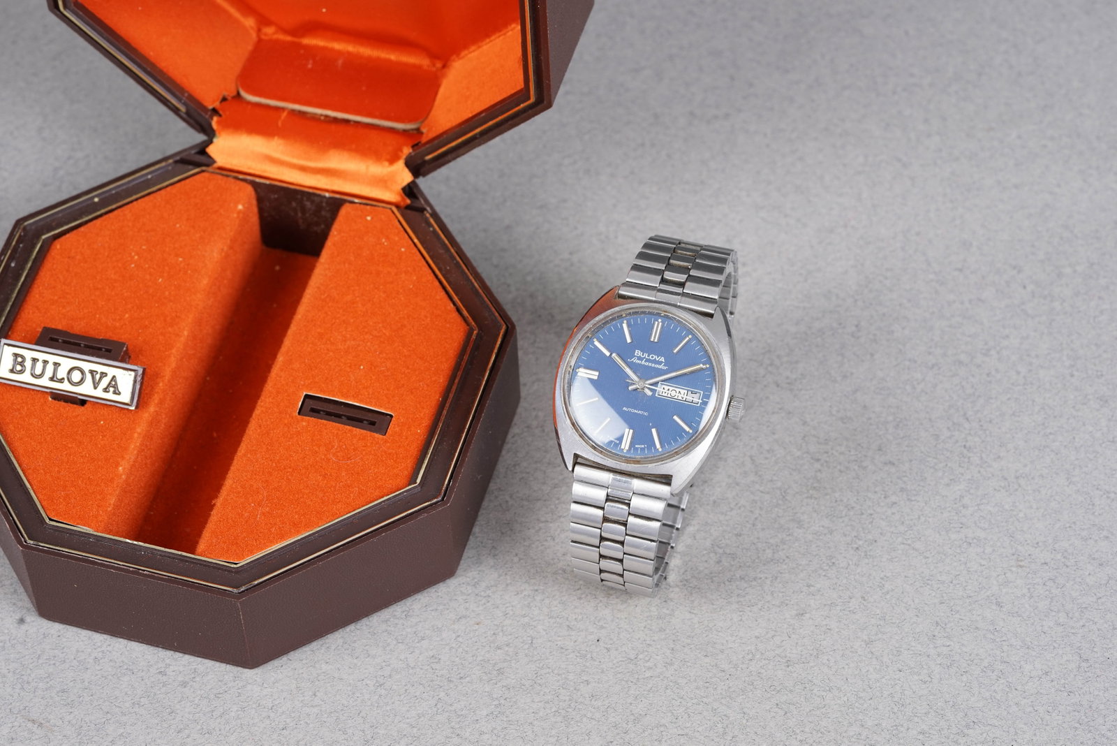 BULOVA AMBASSADOR AUTOMATIC DAY DATE W/ BOX: BULOVA AMBASSADOR AUTOMATIC DAY DATE W/ BOX, this watch is fitted with a circular blue dial with day/date window, baton hour markers and hands. The 36mm steel case is fitted with a Bulova crown and a
