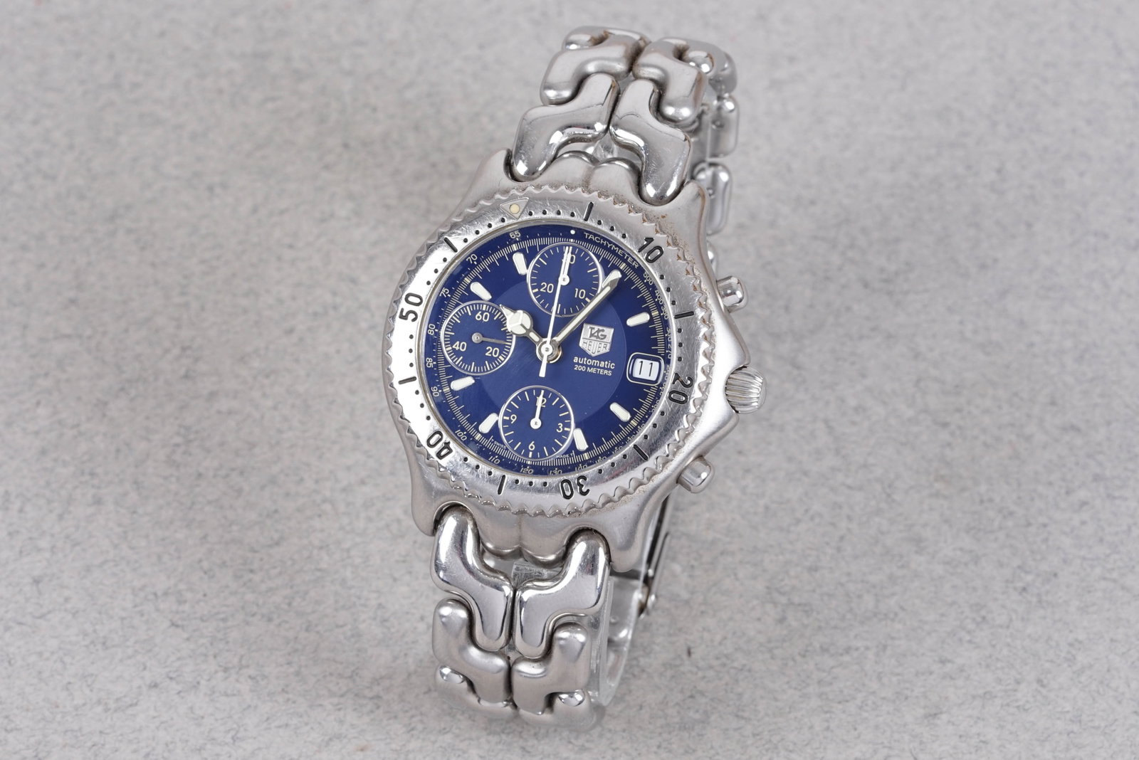 TAG HEUER LINK AUTOMATIC CHRONOGRAPH W/ BOX & PAPERS REF. CG2111-R0: TAG HEUER LINK AUTOMATIC CHRONOGRAPH W/ BOX & PAPERS REF. CG2111-R0 , this watch is fitted with a circular blue dial, 3 sub dials, date window, rotating bezel, baton hour markers and hands. The