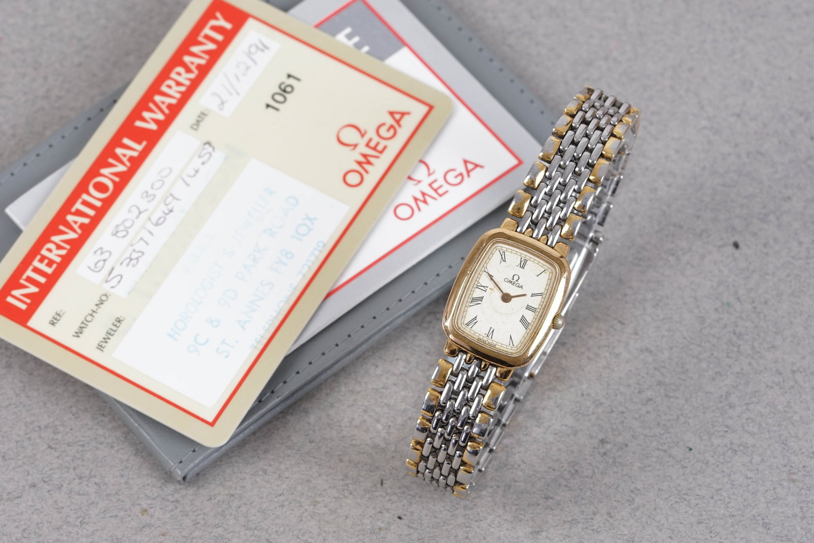 OMEGA DE VILLE TWO TONE W/ GUARANTEE CARD: OMEGA DE VILLE TWO TONE W/ GUARANTEE CARD, this watch is fitted with an oblong white dial with roman numeral hour markers and baton hands. The 23mm plated case is fitted with a crown and a snap case b