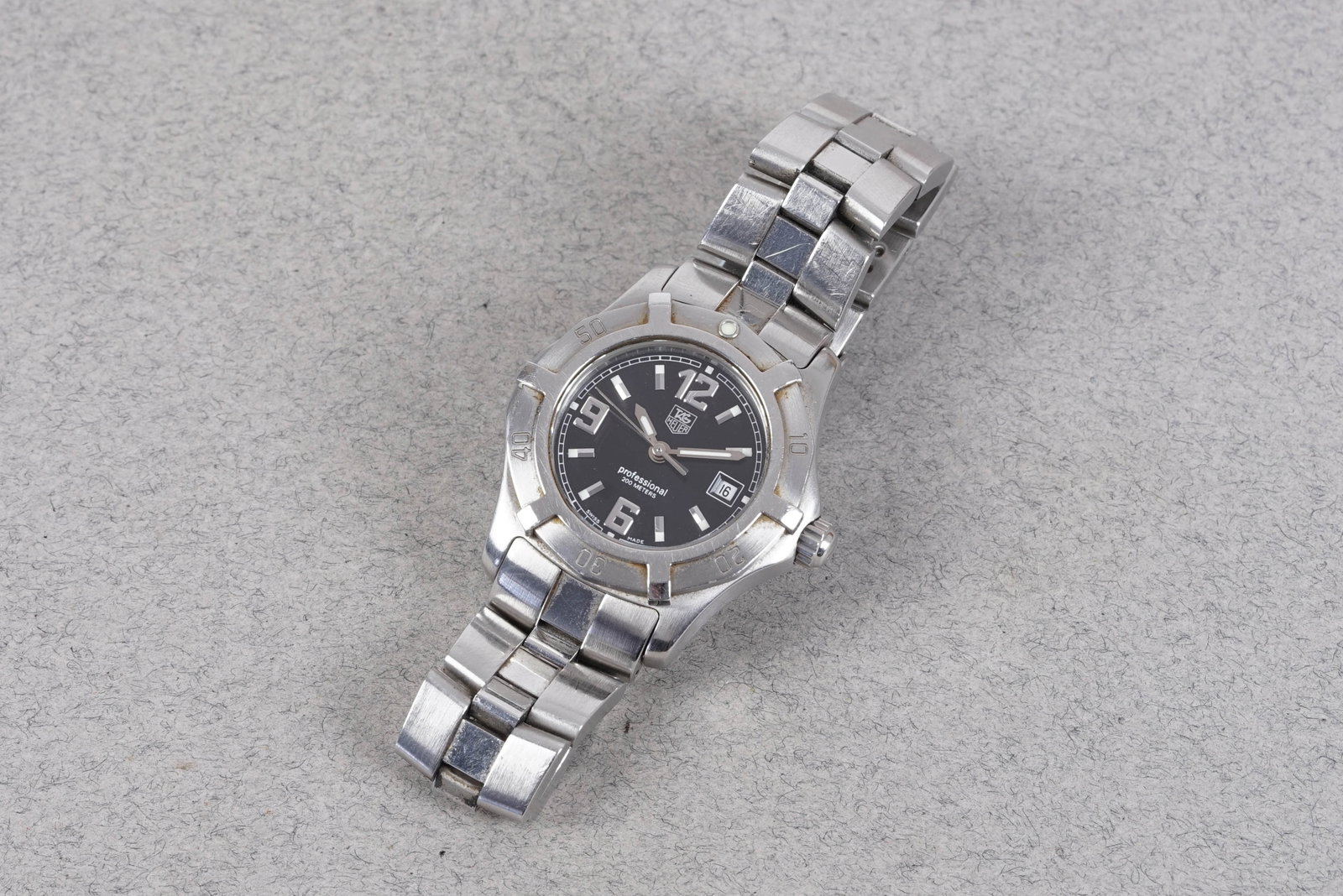 TAG HEUER PROFESSIONAL 200 DATE REF. WN1310-0: TAG HEUER PROFESSIONAL 200 DATE REF. WN1310-0, this watch is fitted with a circular black dial with date window. numeric and baton hour markers and pencil hands. The 28mm steel case is fitted with a s