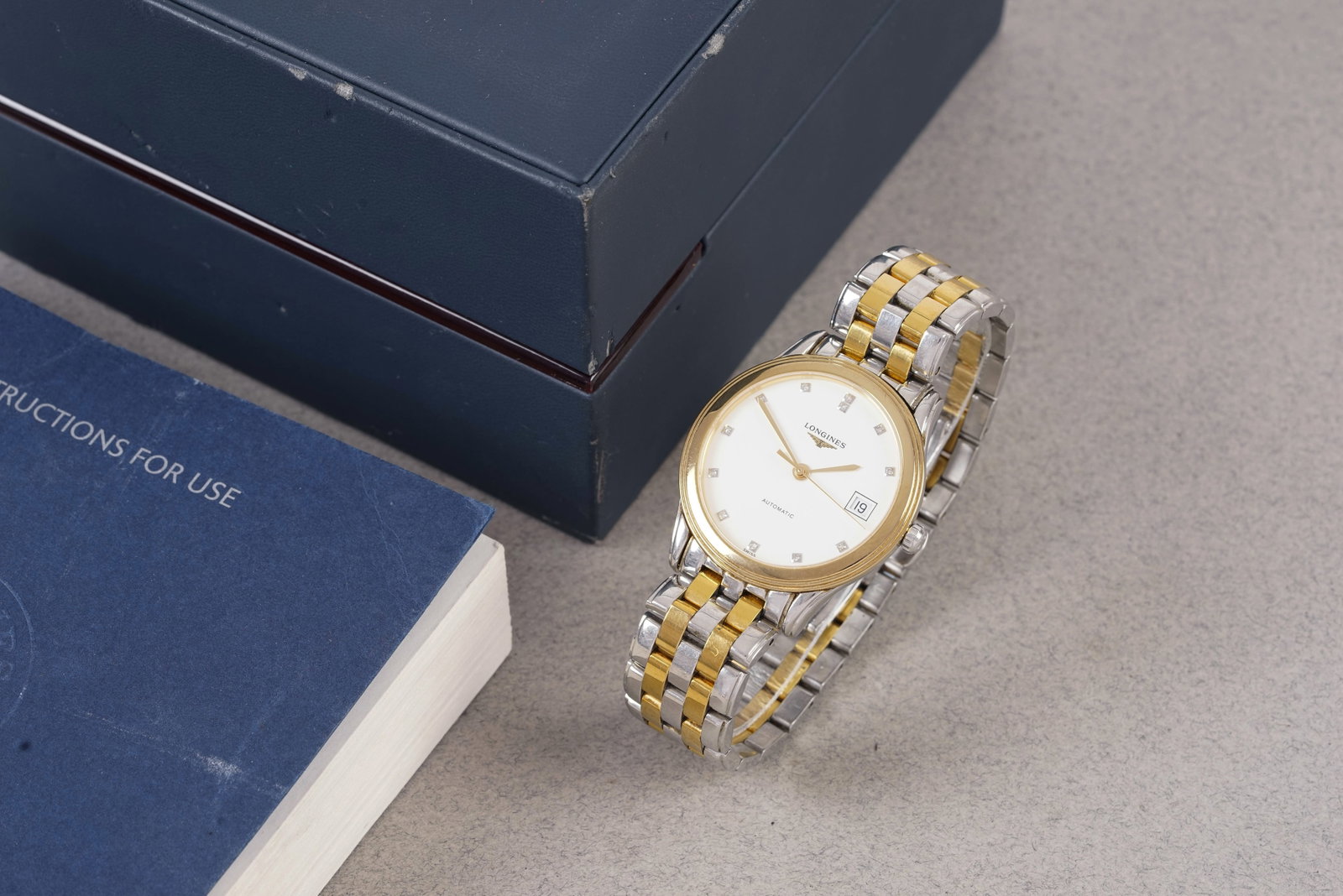 LONGINES DIAMOND AUTOMATIC DATE W/ BOX REF. L4.774.3: LONGINES DIAMOND AUTOMATIC DATE W/ BOX REF. L4.774.3, this watch is a ref. L4.774.3 and is fitted with a circular white dial with a date window, diamond hour markers and sword hands. The 34mm bi-metal