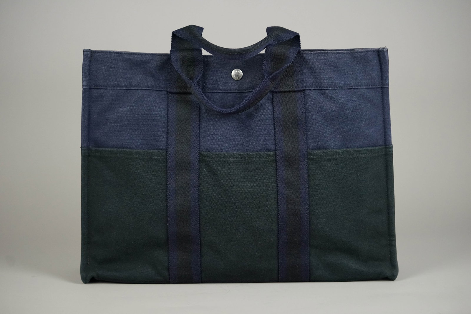 HERMES MM TOTE BAG CANVAS TWO-TONE: HERMES MM TOTE BAG CANVAS TWO-TONE DIMENSIONS: Width 42cm, height 30cm, depth 10cm COLOUR: Blue, black MATERIAL: Canvas ACCESSORIES: N/A CONDITION RANK: B If you have any questions regarding this lot