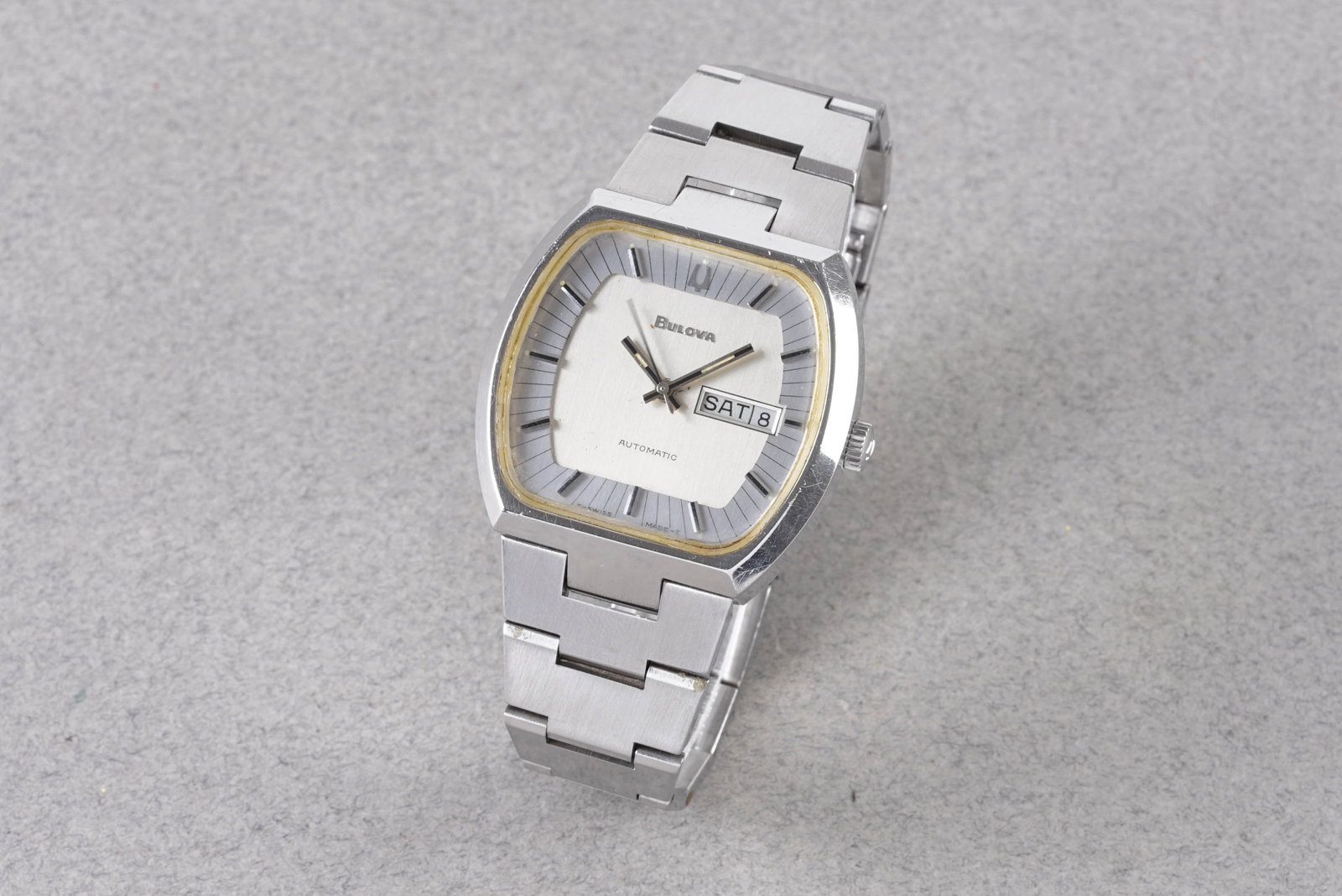 BULOVA AUTOMATIC DAY DATE REF. 11AOACB CIRCA 1977: BULOVA AUTOMATIC DAY DATE REF. 11AOACB CIRCA 1977, this watch is a ref. 11AOACB and is fitted with a silver dial with a day date window, hour markers and hands. The 43mm stainless steel case is