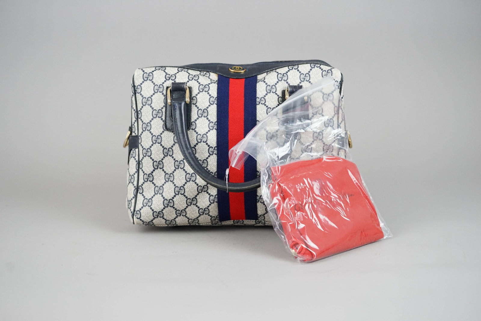 GUCCI OLD GUCCI HANDBAG PVC 3839 TWO-TONE: GUCCI OLD GUCCI HANDBAG PVC 3839 TWO-TONE DIMENSIONS: Width 27cm, height 22cm, depth 6cm COLOUR: Navy, red ACCESSORIES: Dust bag CONDITION RANK: BC - internal discolouration If you have any questions