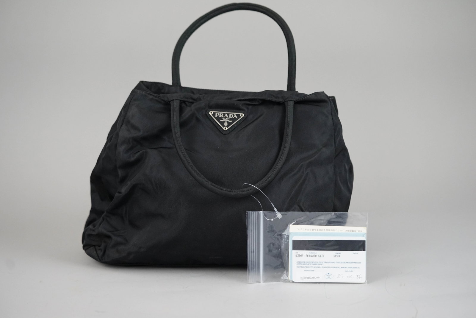PRADA POCONO TOTE BAG NYLON BLACK GALA: PRADA POCONO TOTE BAG NYLON BLACK GALA DIMENSIONS: Width 33cm, height 26cm, depth 11cm COLOUR: black MATERIAL: canvas ACCESSORIES: guarantee card CONDITION RANK: BC If you have any questions regarding