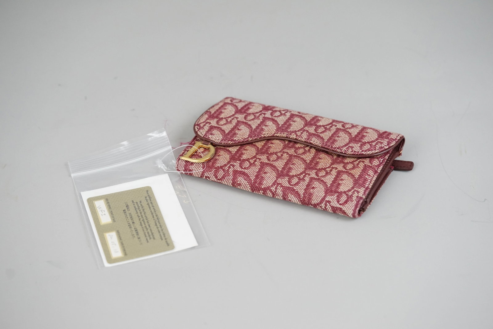 DIOR TROTTER WALLET CANVAS 1021 BORDEAUX GALA: DIOR TROTTER WALLET CANVAS 1021 BORDEAUX GALA DIMENSIONS: Width 16cm, height 10cm, depth 2cm COLOUR: Bordeaux MATERIAL: Canvas ACCESSORIES: Guarantee card CONDITION RANK: BC If you have any questions