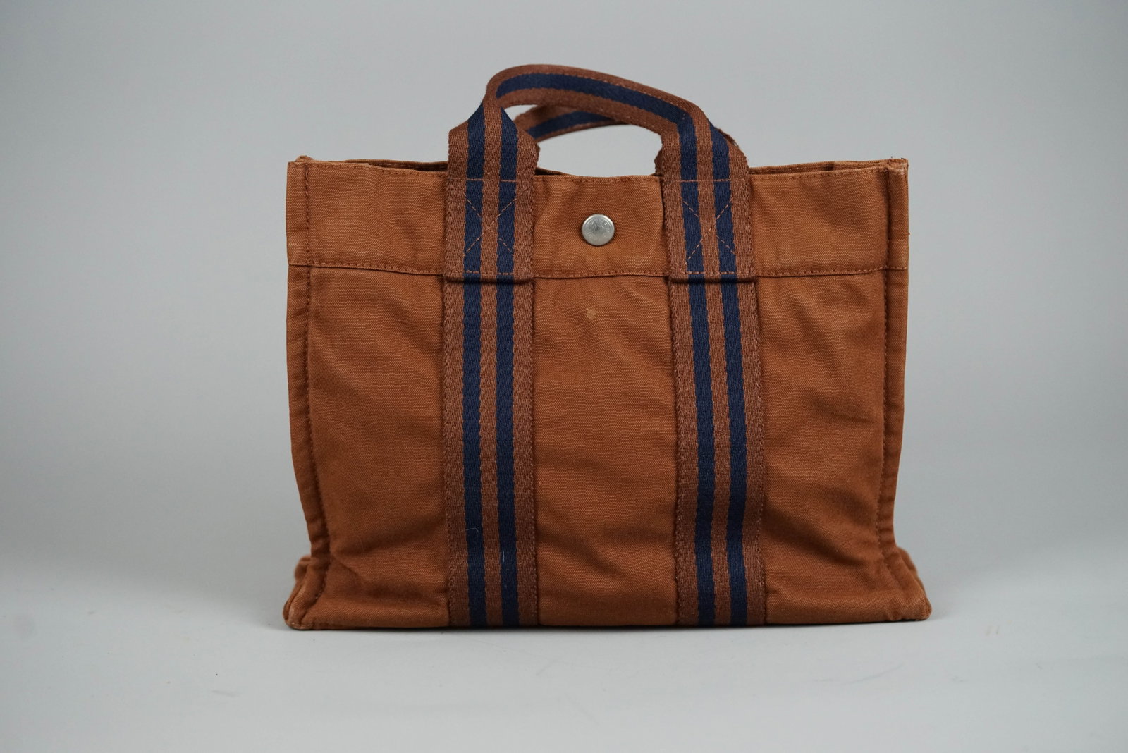 HERMES PM HANDBAG CANVAS TWO-TONE: HERMES PM HANDBAG CANVAS TWO-TONE DIMENSIONS: Width 30cm, height 22cm, depth 8cm COLOUR: Brown, navy MATERIAL: Canvas ACCESSORIES: N/A CONDITION RANK: B If you have any questions regarding this lot