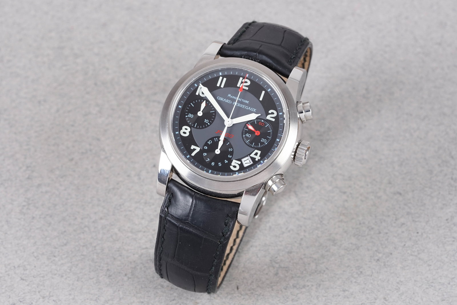 GIRARD PERREGAUX F300 FERRARI CHRONOGRAPH REF. 8020: GIRARD PERREGAUX F300 FERRARI CHRONOGRAPH REF. 8020, this watch is a ref. 8020 and is fitted with a round black dial with a date window, number hour markers and pencil style hands. The 38mm steel