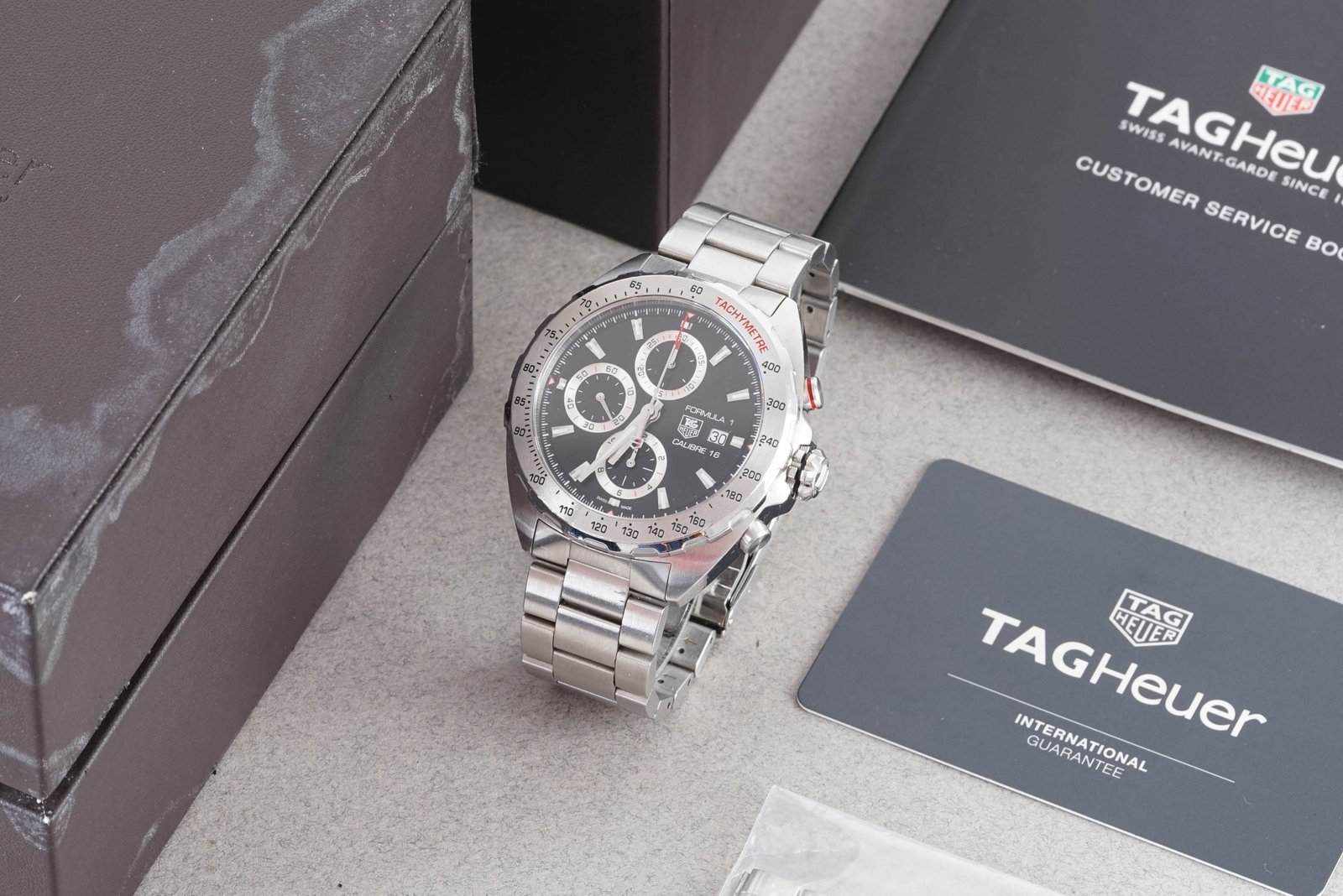 TAG HEUER FORMULA 1 CALIBRE 16 AUTOMATIC CHRONOGRAPH W/ BOX REF. CAZ2010: TAG HEUER FORMULA 1 CALIBRE 16 AUTOMATIC CHRONOGRAPH W/ BOX REF. CAZ2010, this watch is a ref. CAZ2010 and is fitted with a circular black triple register dial with a date window, hour markers and