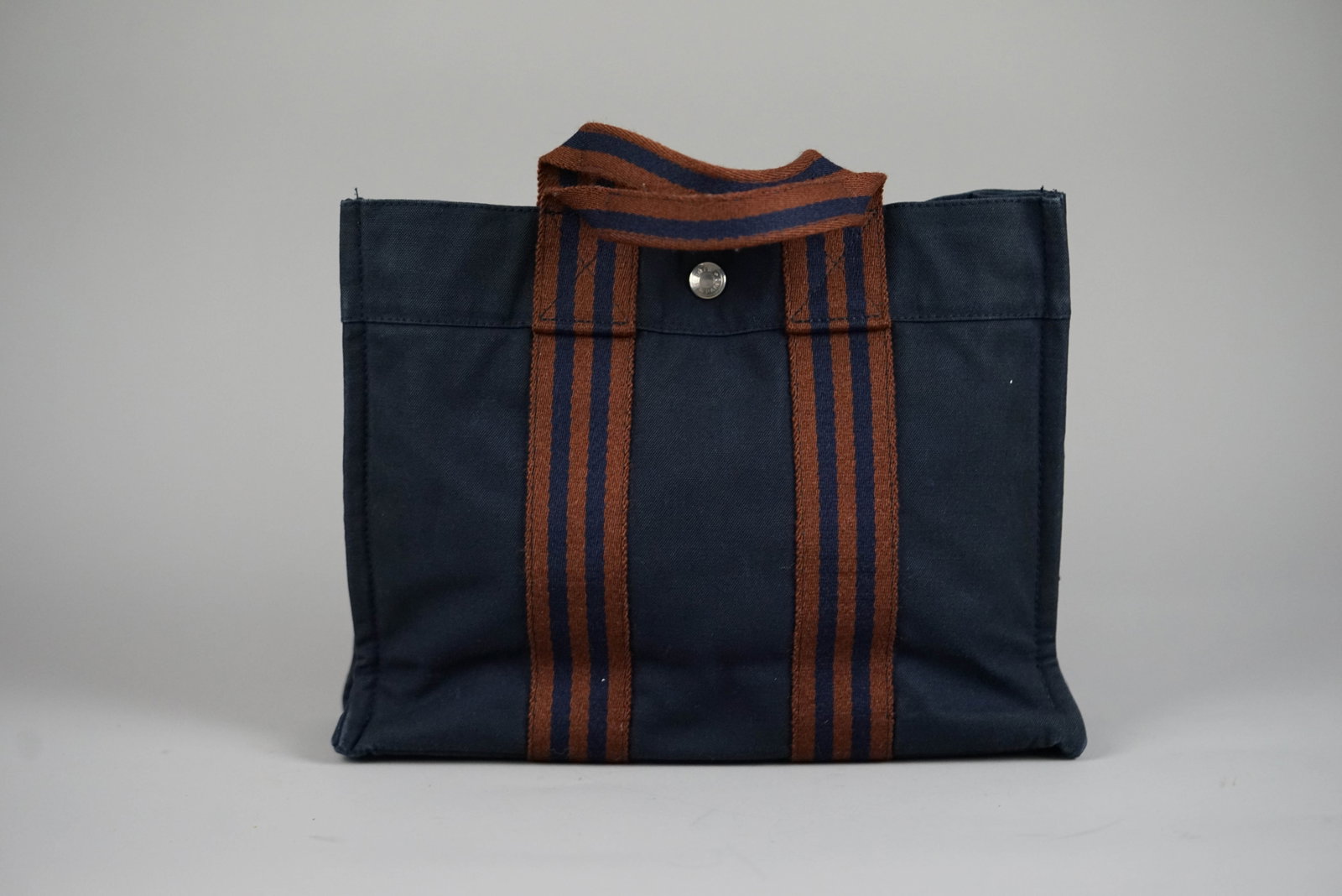 HERMES PM HANDBAG CANVAS TWO-TONE: HERMES PM HANDBAG CANVAS TWO-TONE DIMENSIONS: Width 30cm, height 22cm, depth 8cm COLOUR: Navy MATERIAL: Canvas ACCESSORIES: N/A CONDITION RANK: B If you have any questions regarding this lot please