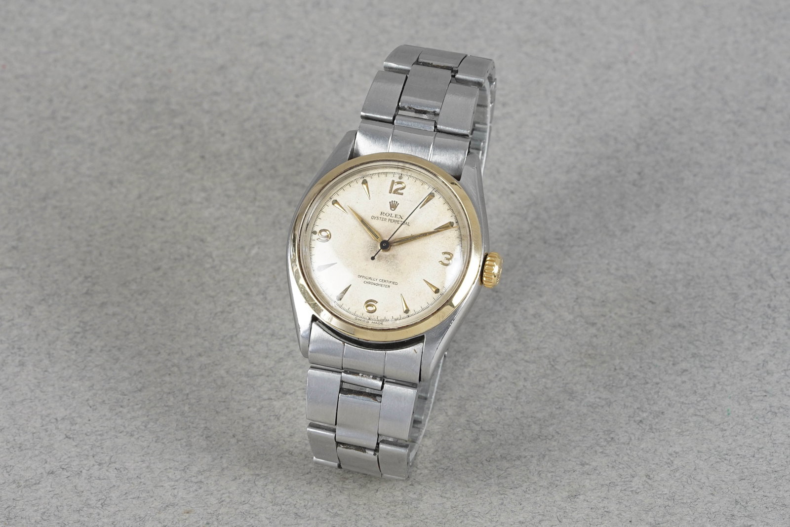 ROLEX OYSTER PERPETUAL STEEL & GOLD WRISTWATCH REF. 6084 CIRCA 1952: ROLEX OYSTER PERPETUAL STEEL & GOLD WRISTWATCH REF. 6084 CIRCA 1952 DIAL: Circular patina dial, gold alpha, cone hour markers CASE: 34mm stainless steel, gold bezel, gold Rolex crown, screw down