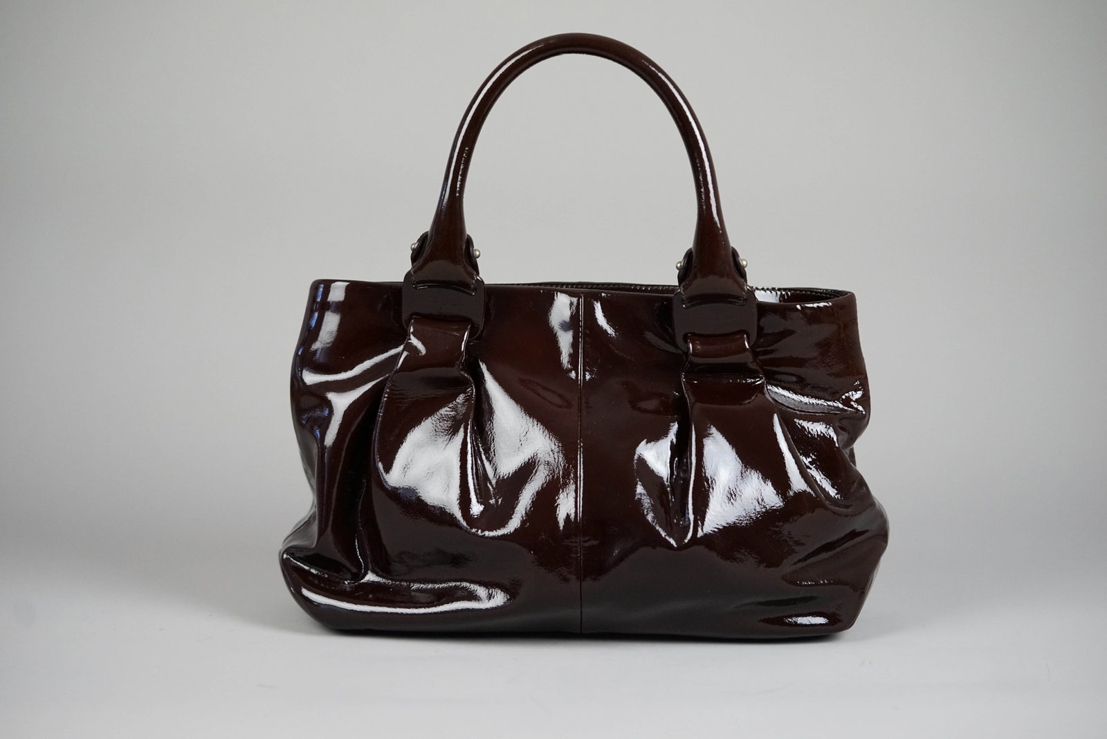 SALVATORE FERRAGAMO VARA HANDBAG ENAMEL BROWN: SALVATORE FERRAGAMO VARA HANDBAG BROWN DIMENSIONS: Width 38cm, height 24cm, depth 10cm COLOUR: Brown ACCESSORIES: N/A CONDITION RANK: B If you have any questions regarding this lot please contact us.