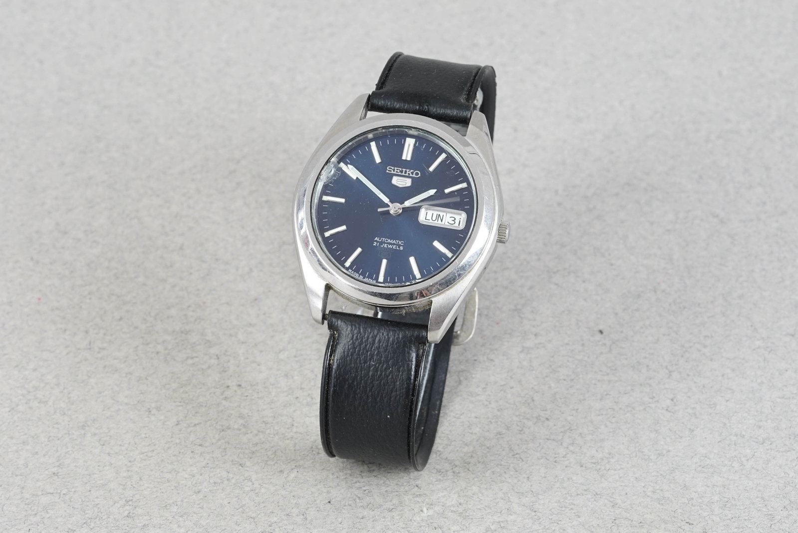 SEIKO 5 AUTOMATIC DAY DATE WRISTWATCH: SEIKO 5 AUTOMATIC DAY DATE WRISTWATCH DIAL: Circular blue, silver hour markers, day date window CASE: 37mm stainless steel, screw down case back MOVEMENT: Automatic BRACELET OR STRAP: Black strap
