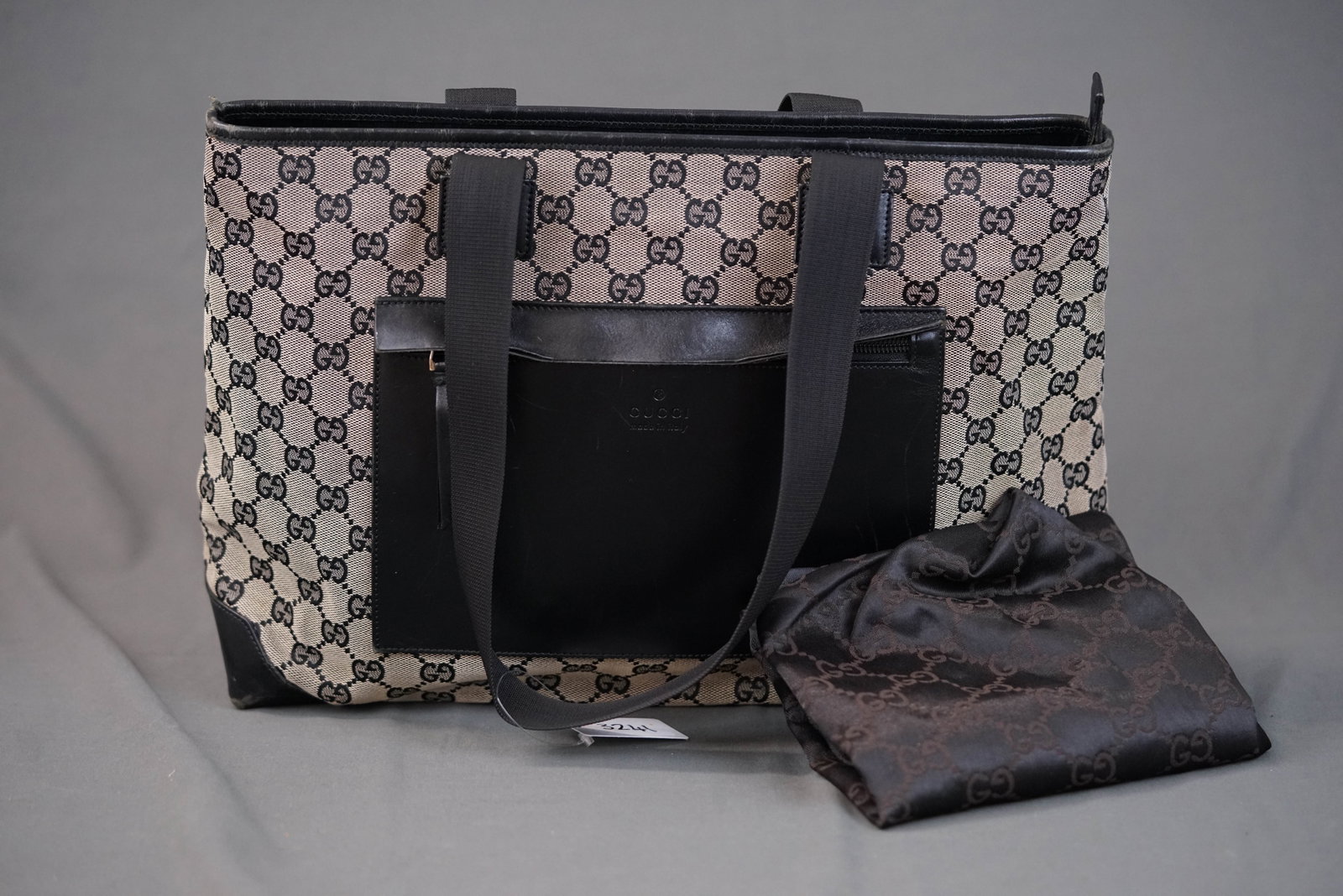 GUCCI GG CANVAS TOTE BAG 3444: GUCCI GG CANVAS TOTE BAG 3444 DIMENSIONS: Width 14cm, height 26cm, depth 13cm COLOUR: black/grey MATERIAL: coated canvas, leather ACCESSORIES: dust cover CONDITION RANK: wear commensurate with age If