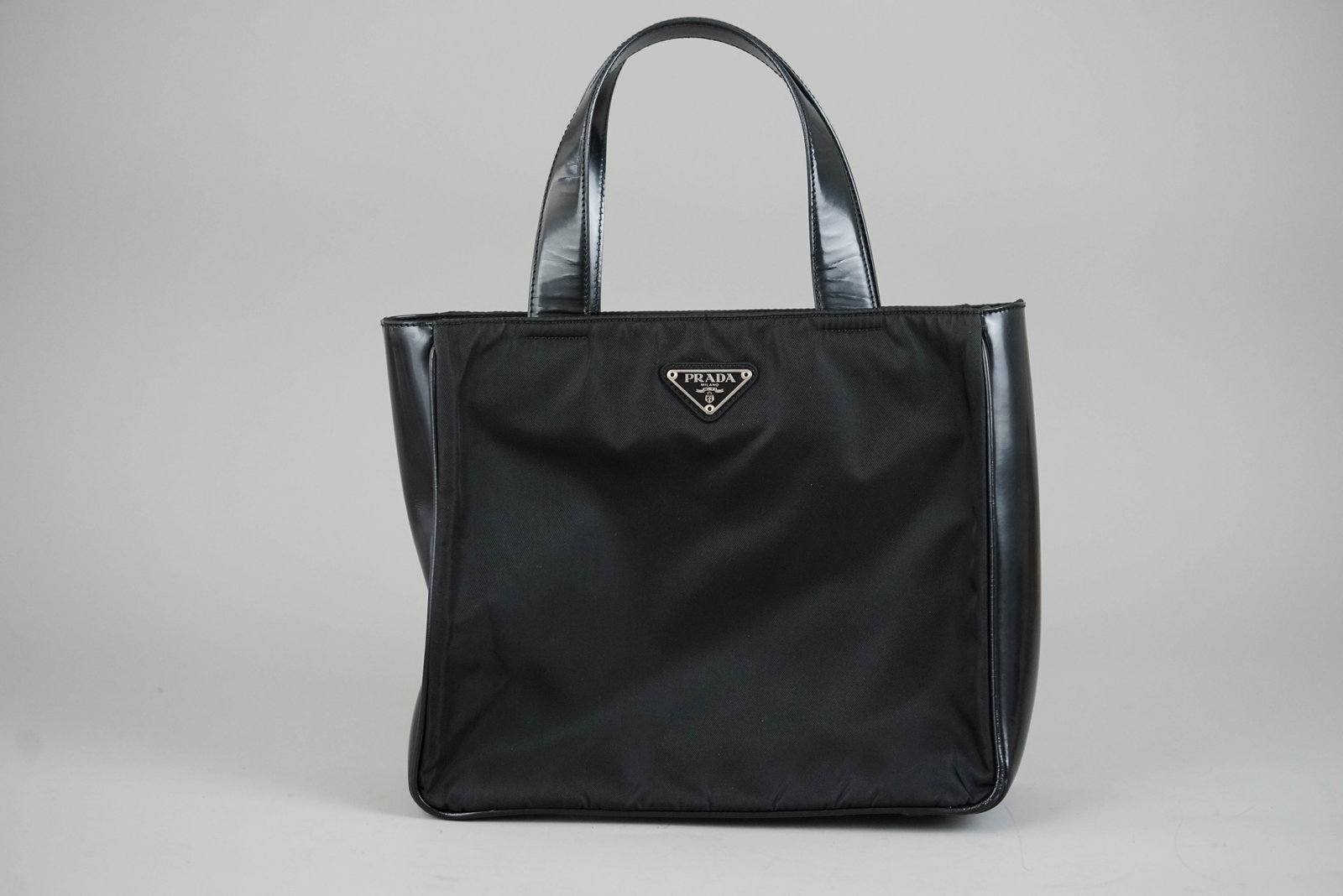 PRADA POCONO TOTE BAG NYLON BLACK: PRADA POCONO TOTE BAG NYLON BLACK DIMENSIONS: Width 26cm, height 23cm, depth 9cm COLOUR: black MATERIAL: nylon ACCESSORIES: n/a CONDITION RANK: B If you have any questions regarding this lot please