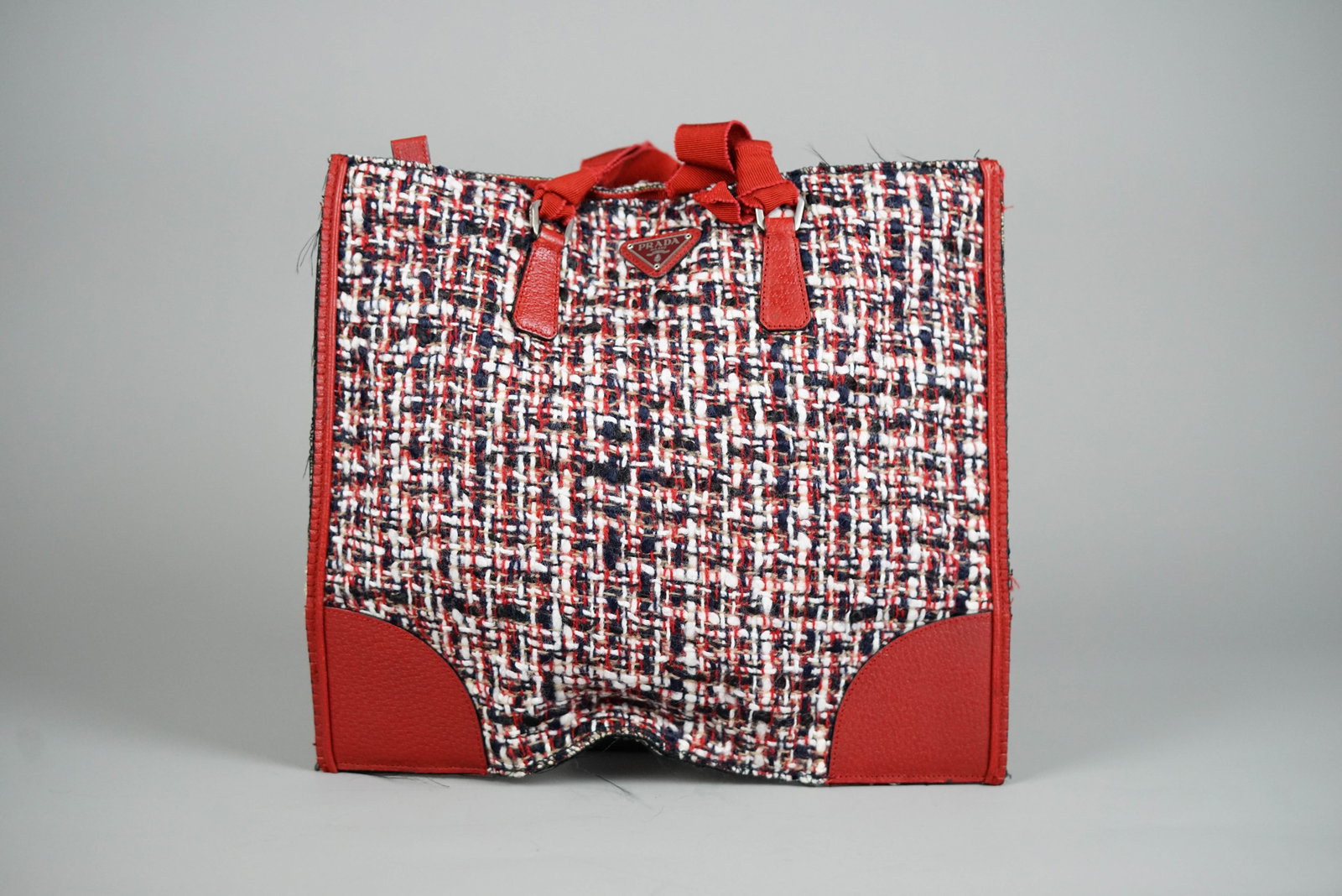 PRADA HANDBAG TWEED MULTICOLOR GALA: PRADA HANDBAG TWEED MULTICOLOR GALA DIMENSIONS: Width 32cm, height 27cm, depth 1cm COLOUR: Red, white, black MATERIAL: Tweed ACCESSORIES: N/A CONDITION RANK: BC If you have any questions regarding
