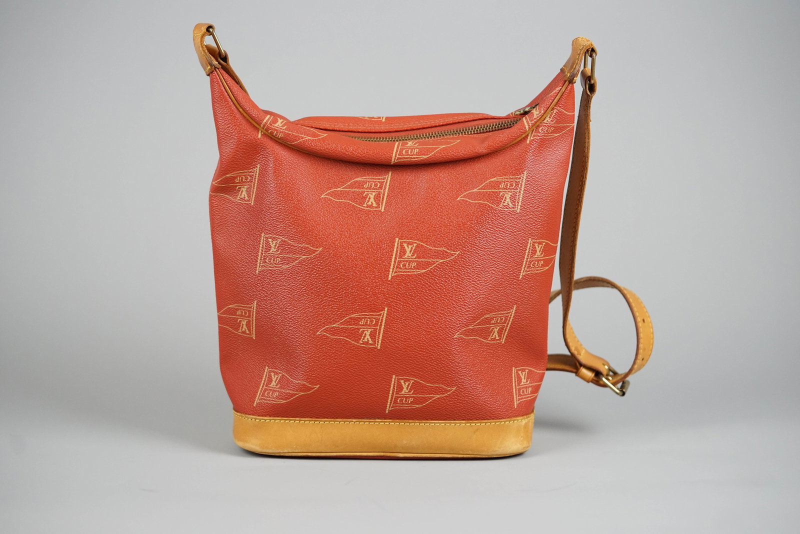 LOUIS VUITTON LE TOUQUET SHOULDER BAG M80027 1113 LOUIS VUITTON CUP LIMITED EDITION: LOUIS VUITTON LE TOUQUET SHOULDER BAG M80027 1113 LOUIS VUITTON CUP LIMITED EDITION DIMENSIONS: Width 22cm, height 25cm, depth 9cm COLOUR: Red, brown ACCESSORIES: N/A CONDITION RANK: B If you have