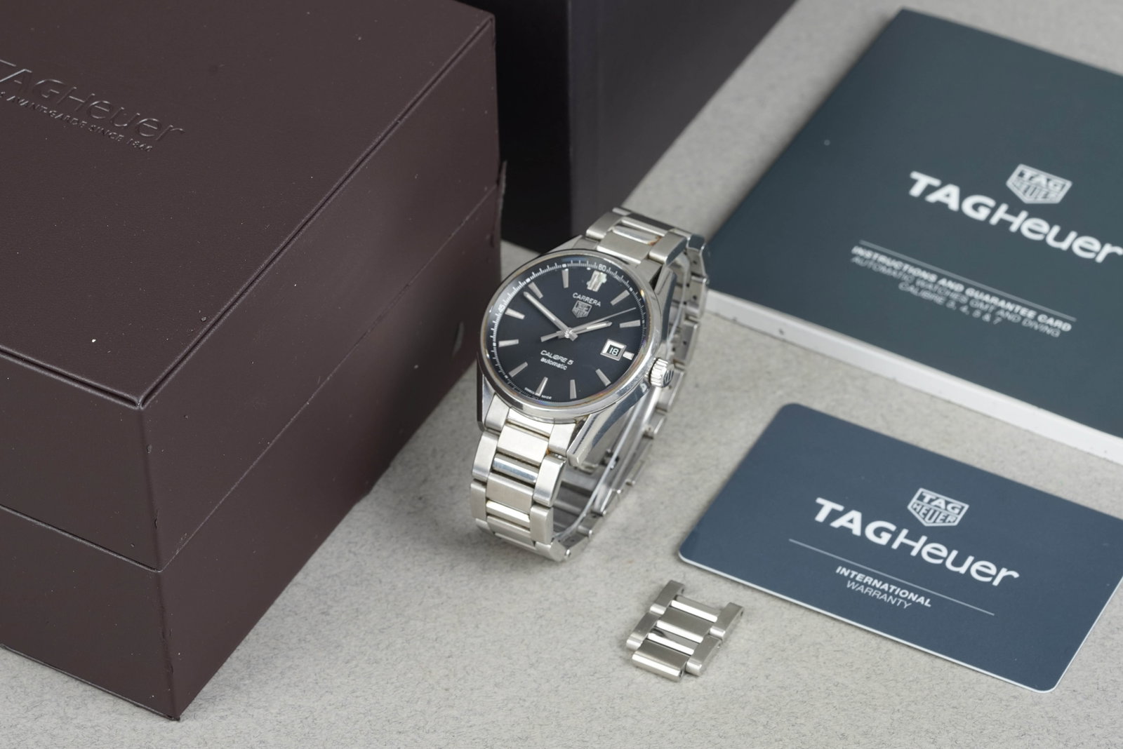 TAG HEUER CARRERA CALIBRE 5 W/ BOX & GUARANTEE CARD REF. WAR211A-2: TAG HEUER CARRERA CALIBRE 5 W/ BOX & GUARANTEE CARD REF. WAR211A-2 DIAL: Circular black dial, applied hour markers, date window CASE: 38mm stainless steel, exhibition case back MOVEMENT: