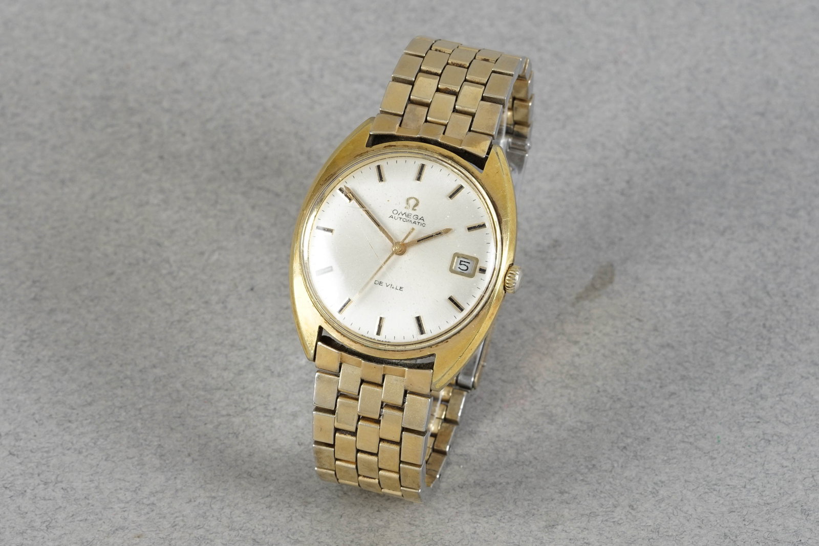 OMEGA SEAMASTER DE VILLE AUTOMATIC DATE WRISTWATCH: OMEGA SEAMASTER DE VILLE AUTOMATIC DATE WRISTWATCH, this watch is fitted with a white round dial with date window, baton hour markers and hands. The 34mm gold plated case is fitted with an omega