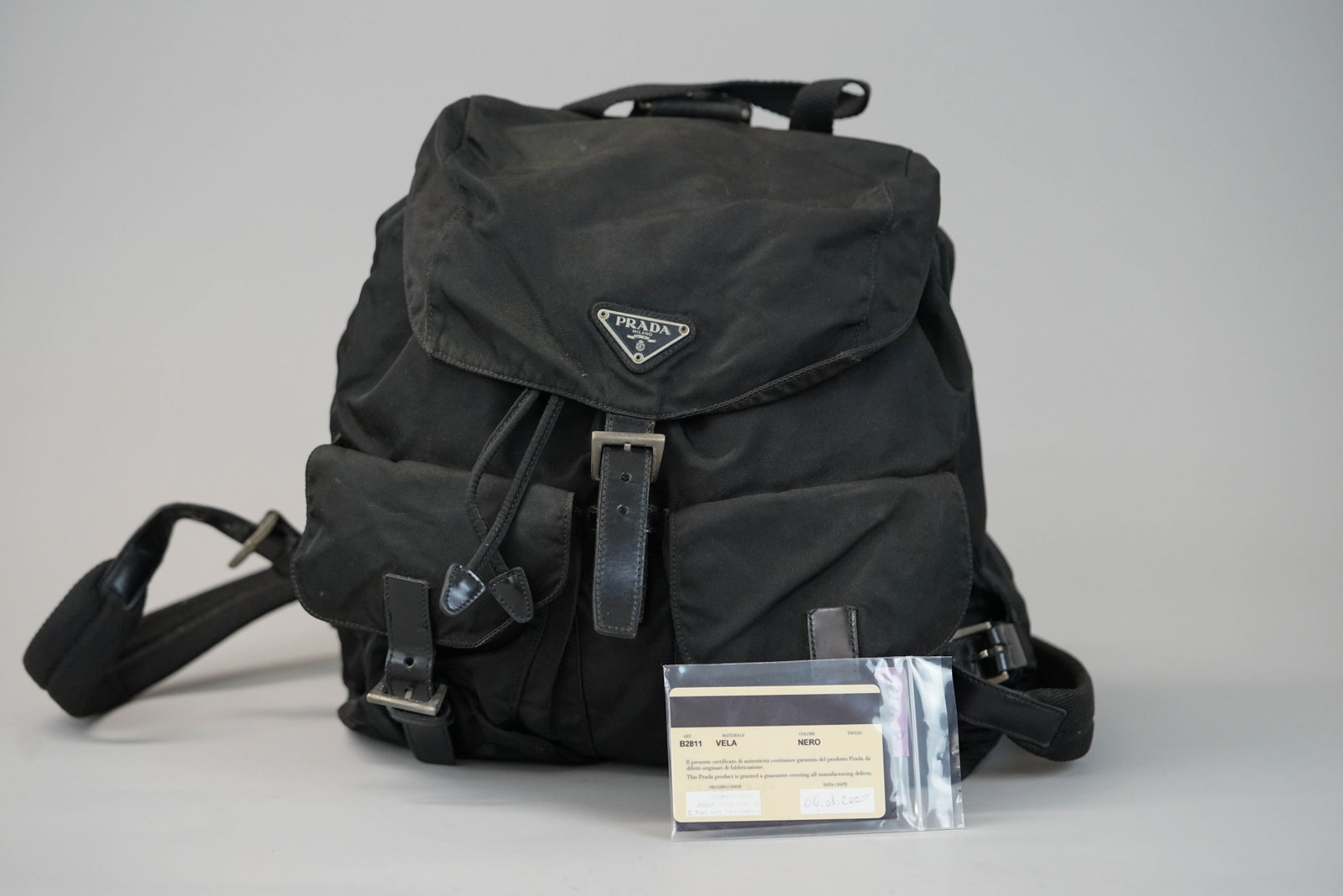PRADA BLACK NYLON BACKPACK: PRADA BLACK NYLON BACKPACK DIMENSIONS: Width 29cm, height 29cm, depth 15cm COLOUR: Black MATERIAL: Nylon leather trim ACCESSORIES: guarentee card dated 2000 CONDITION RANK:BC If you have any